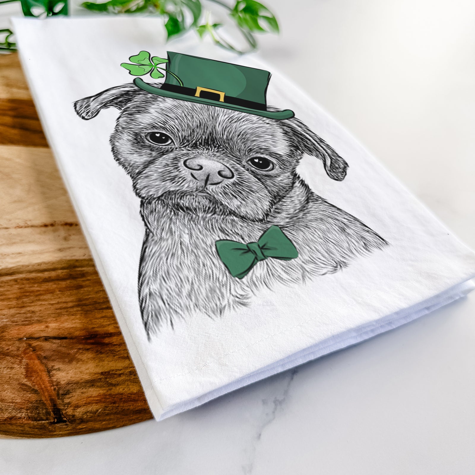 Hand-drawn sketch of Koko the Shih Tzu wearing a St. Patrick's Day leprechaun hat and bow tie on a tea towel