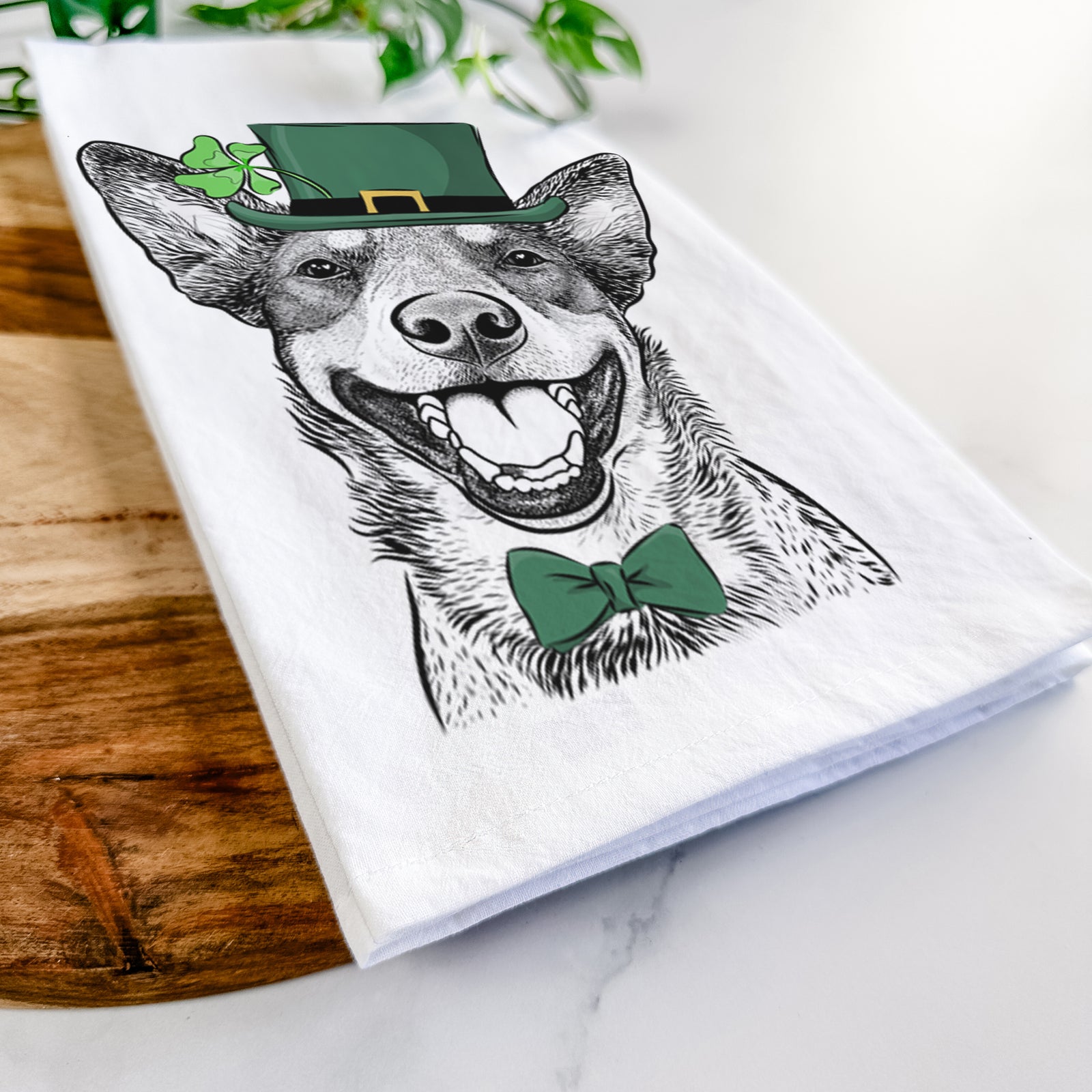 Hand-drawn sketch of Lily the Australian Cattle Dog wearing a St. Patrick's Day leprechaun hat and bow tie on a tea towel