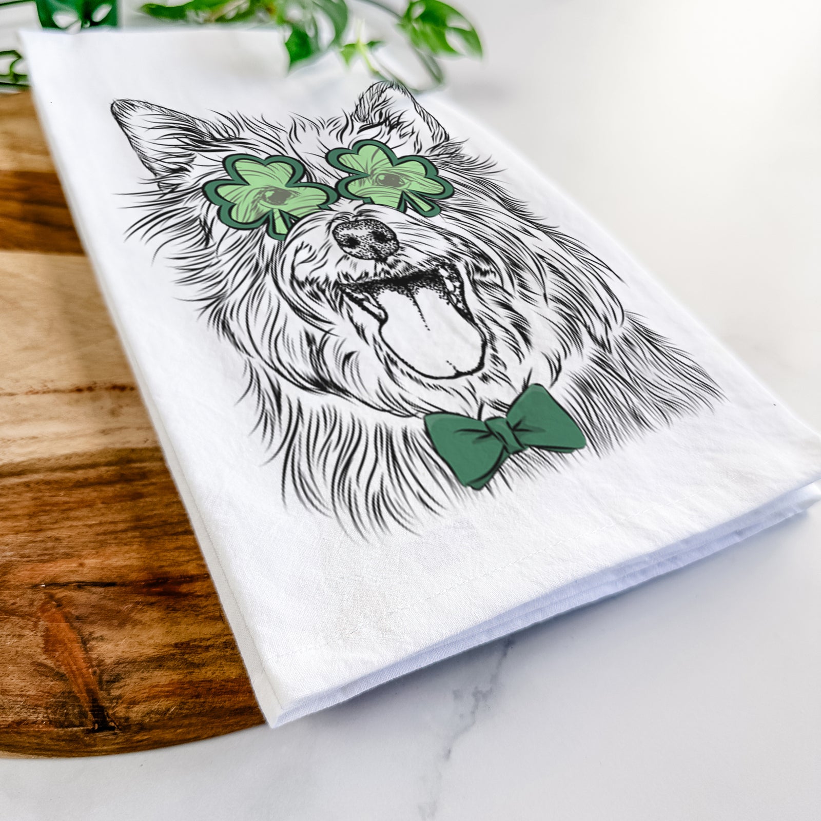 Hand-drawn sketch of Middy the Australian Terrier wearing a St. Patrick's Day leprechaun hat and bow tie on a tea towel