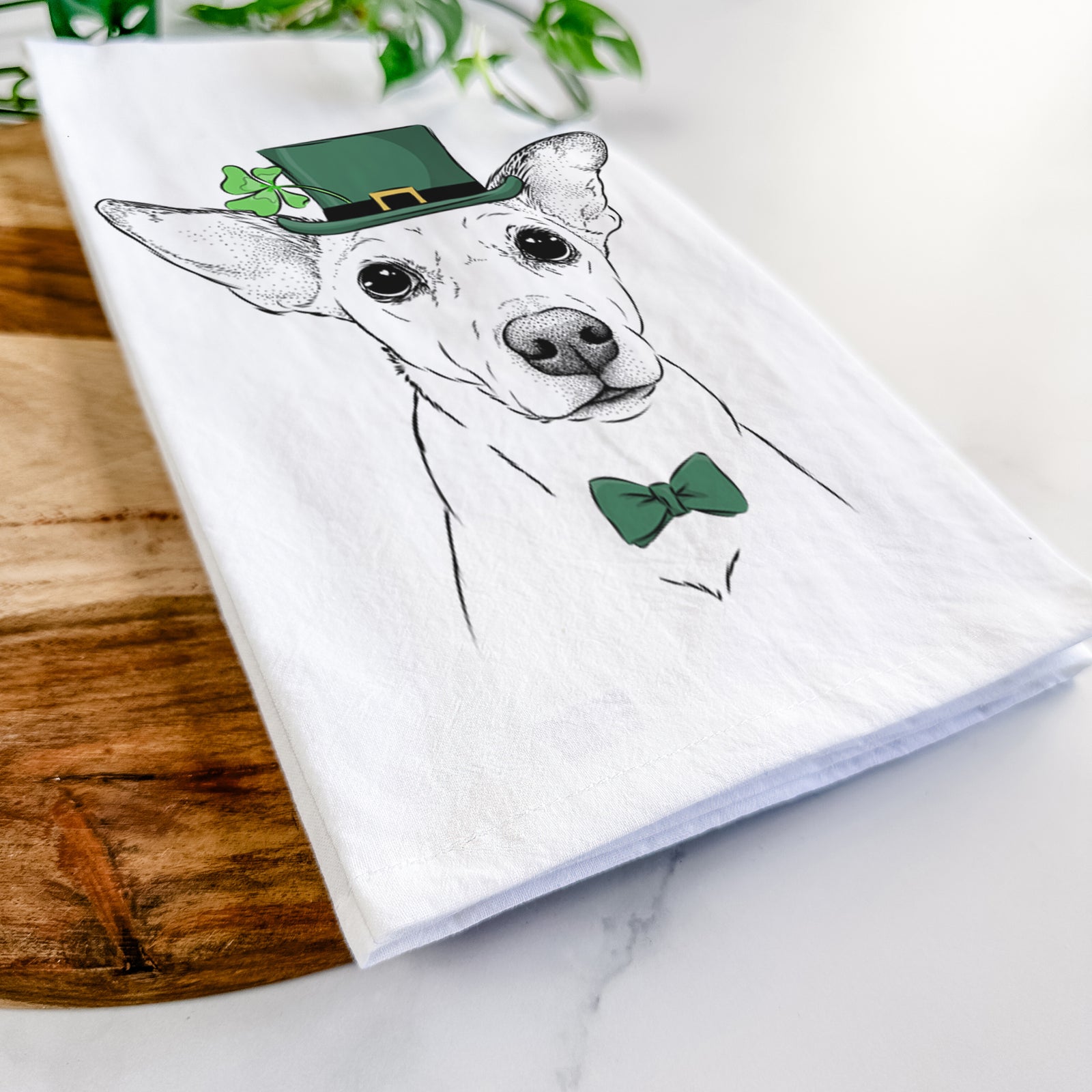 Hand-drawn sketch of Molly the Jack Russell Terrier wearing a St. Patrick's Day leprechaun hat and bow tie on a tea towel