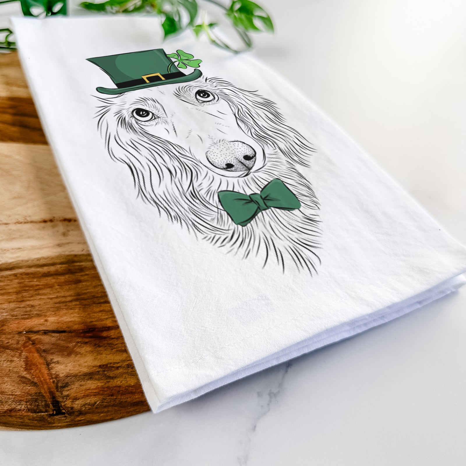 Hand-drawn sketch of Mr. Rusty the Long Haired Dachshund wearing a St. Patrick's Day leprechaun hat and bow tie on a tea towel