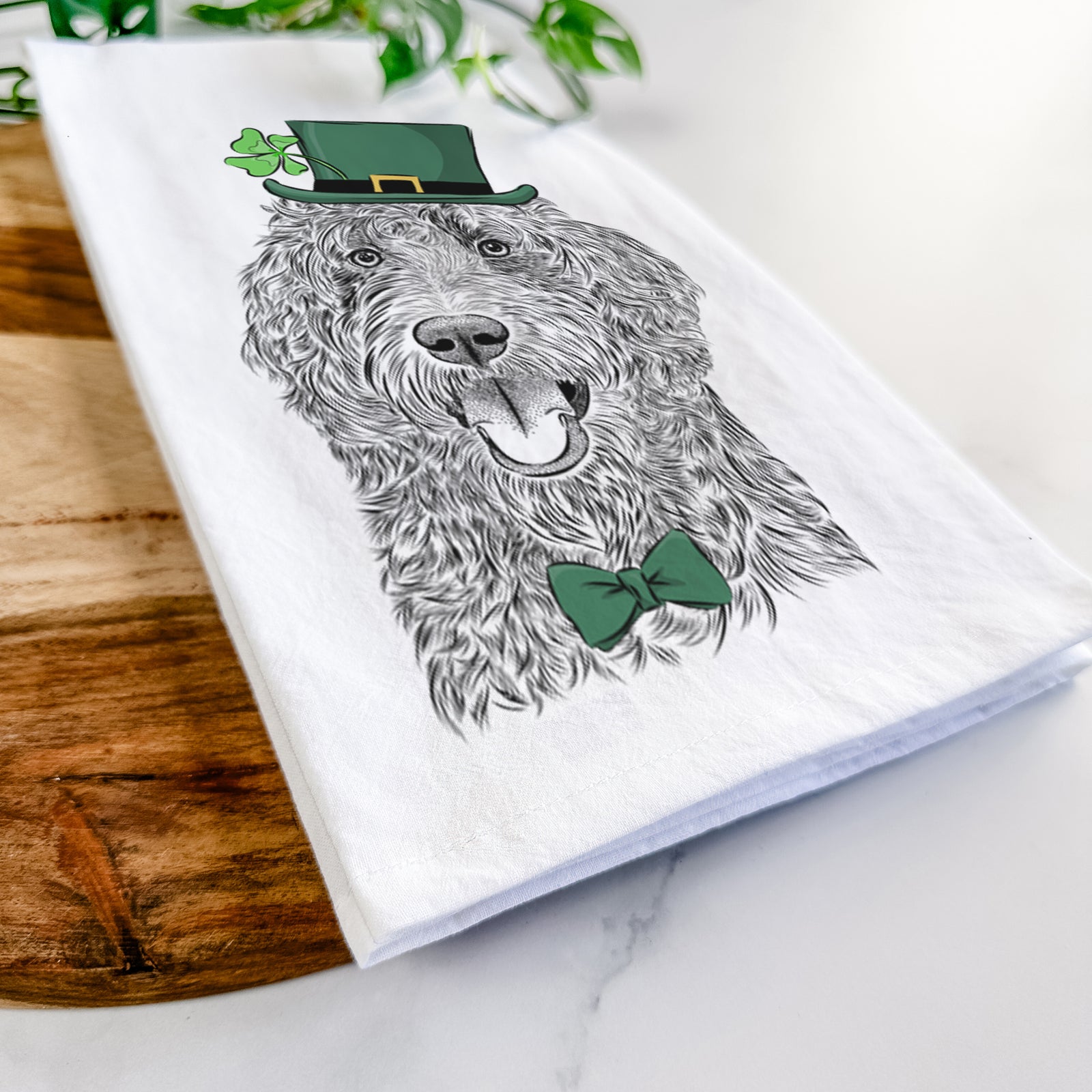 Hand-drawn sketch of Murr Dog the Labradoodle wearing a St. Patrick's Day leprechaun hat and bow tie on a tea towel