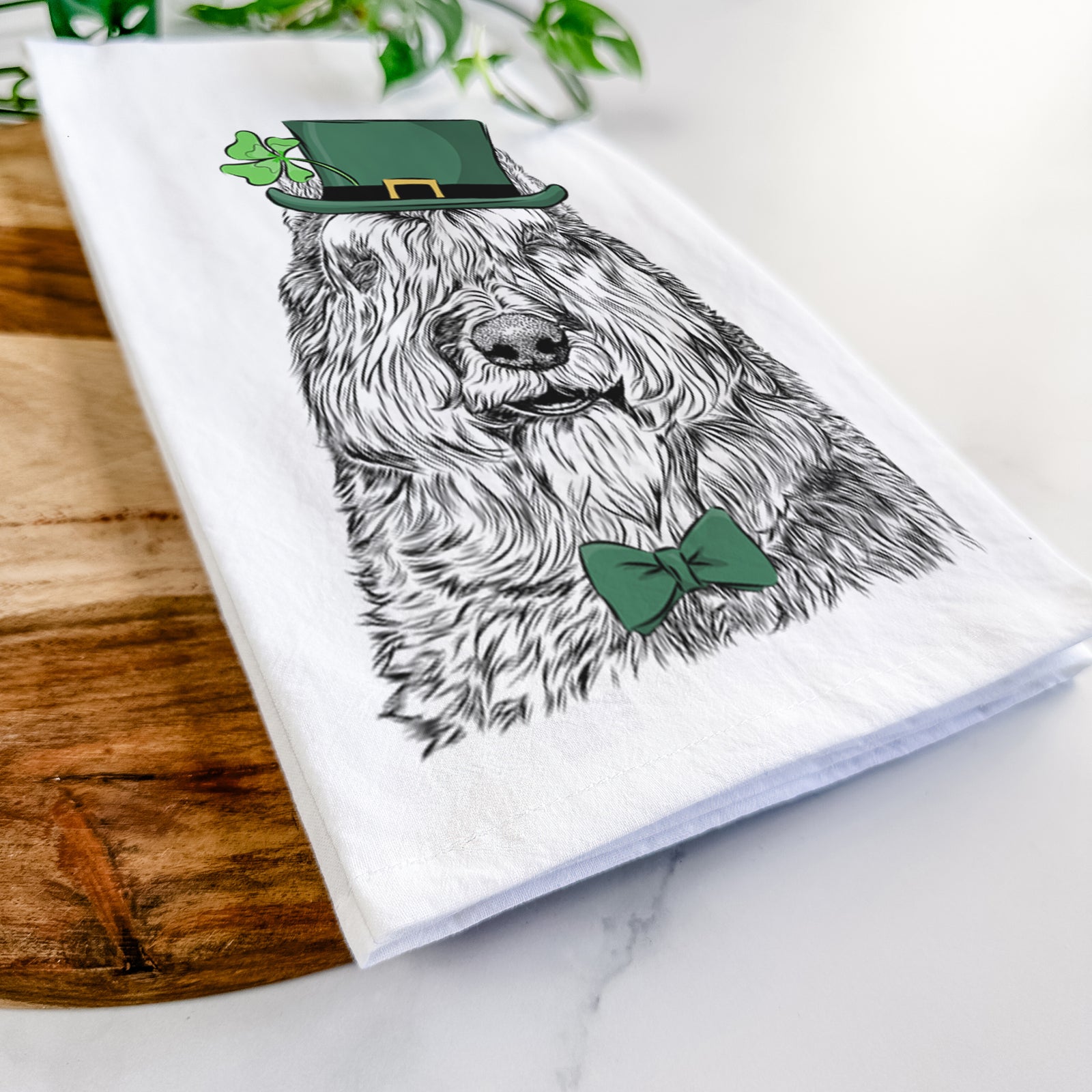 Hand-drawn sketch of Sabre the Bouvier Des Flandres wearing a St. Patrick's Day leprechaun hat and bow tie on a tea towel