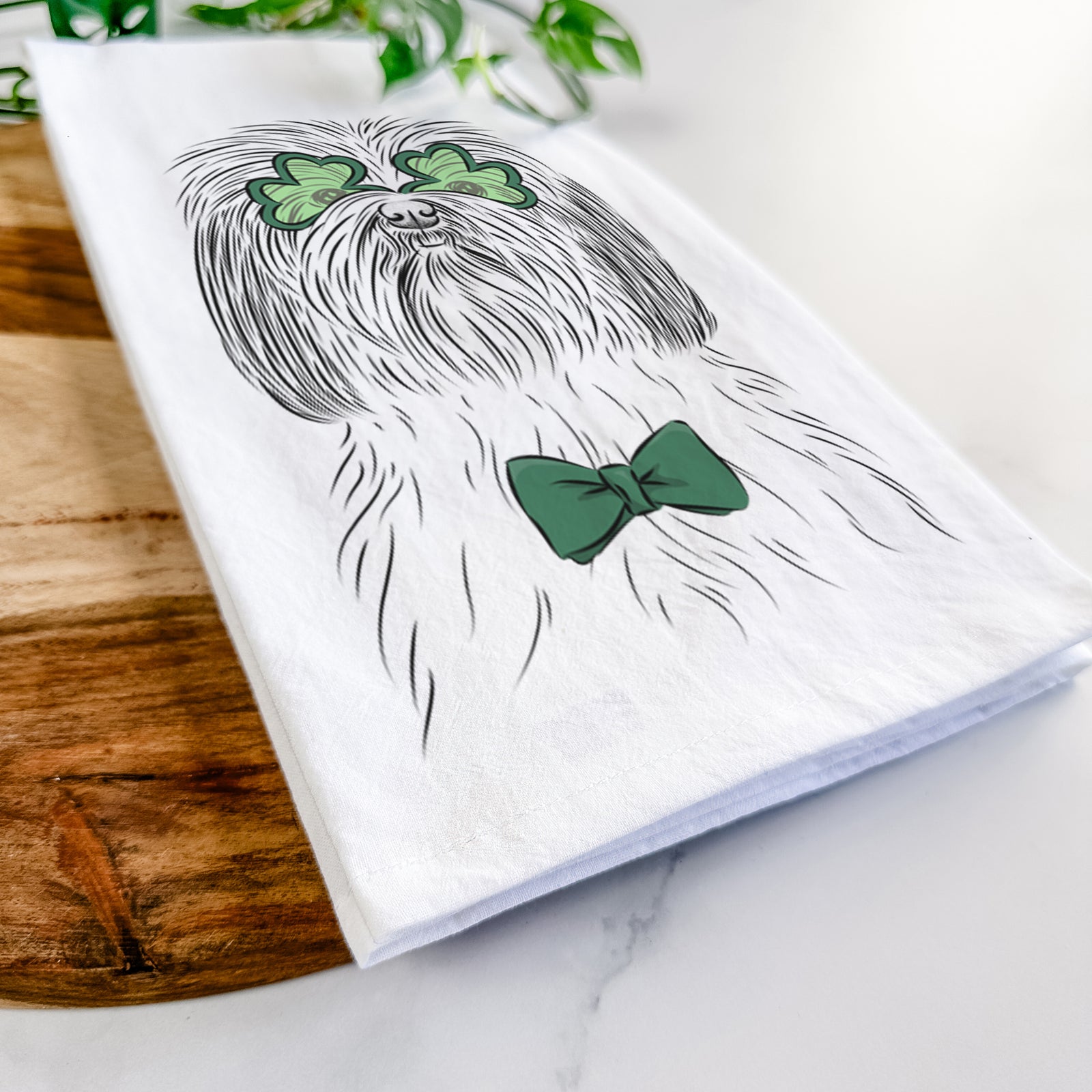 Hand-drawn sketch of Scully the Shih Tzu wearing a St. Patrick's Day leprechaun hat and bow tie on a tea towel
