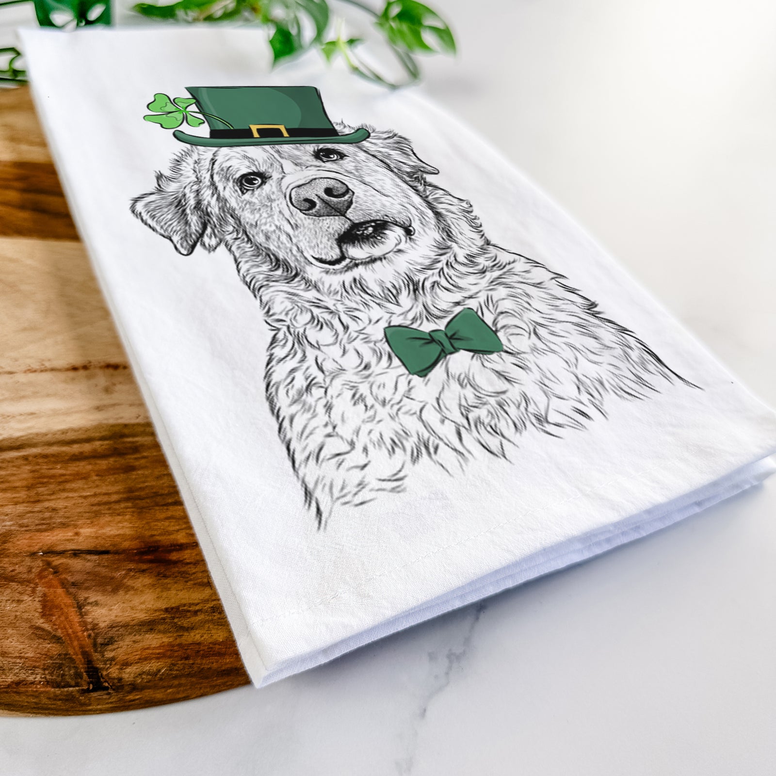 Hand-drawn sketch of Smokey Jam the Middle Eastern Village Dog wearing a St. Patrick's Day leprechaun hat and bow tie on a tea towel
