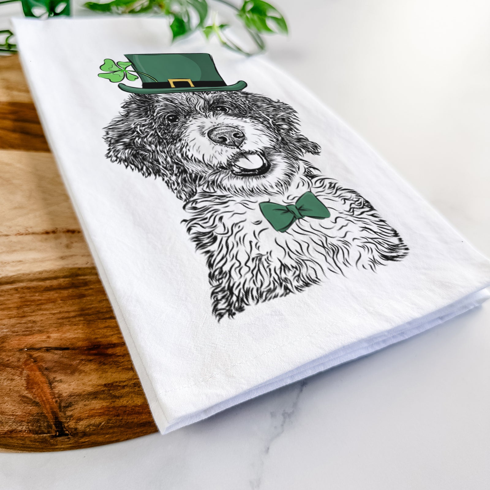 Hand-drawn sketch of Smoky the Bernedoodle Puppy wearing a St. Patrick's Day leprechaun hat and bow tie on a tea towel