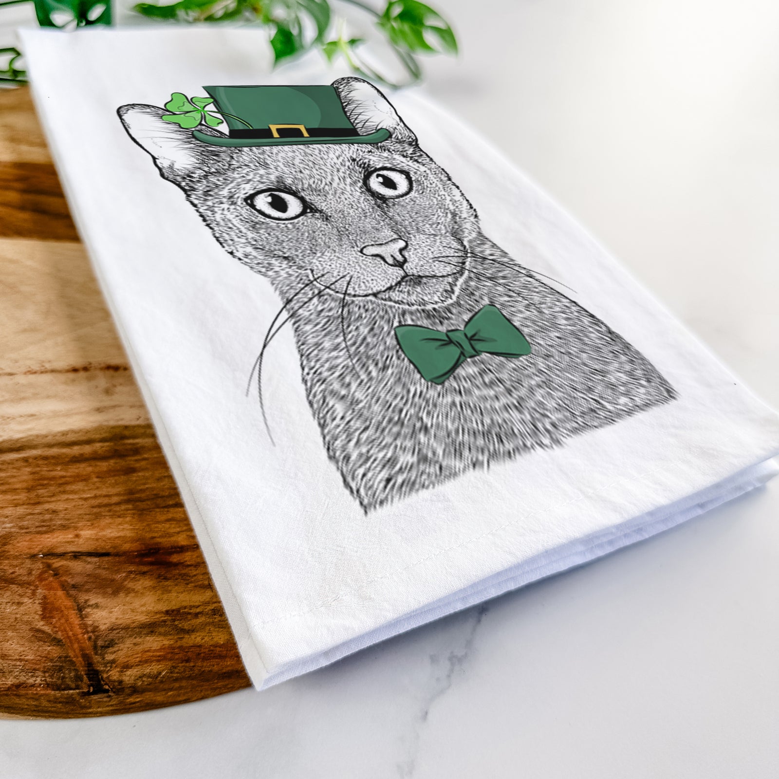 Hand-drawn sketch of Stanley the Russian Blue Cat wearing a St. Patrick's Day leprechaun hat and bow tie on a tea towel