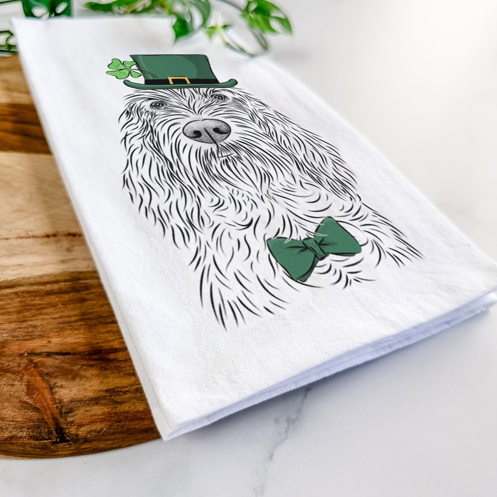 Hand-drawn sketch of Stefano the Spinone Italiano wearing a St. Patrick's Day leprechaun hat and bow tie on a tea towel