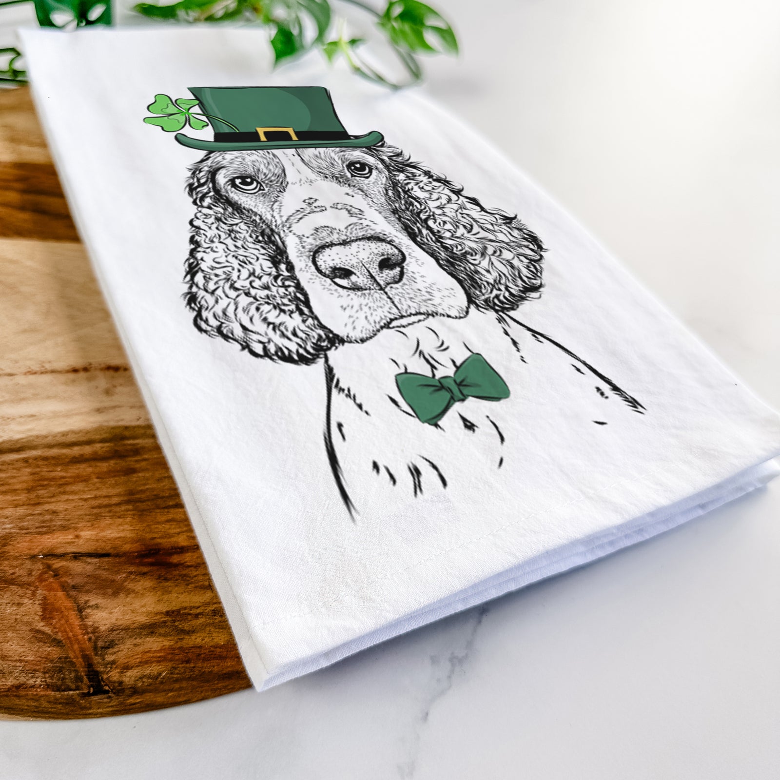 Hand-drawn sketch of Wilbur the English Springer Spaniel wearing a St. Patrick's Day leprechaun hat and bow tie on a tea towel