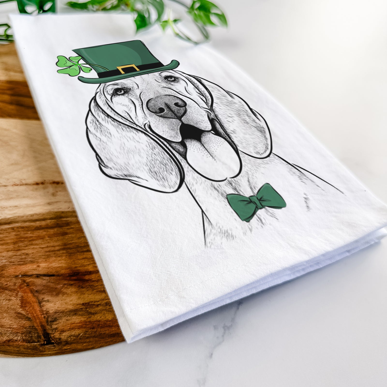 Hand-drawn sketch of Winston the Redbone Coonhound wearing a St. Patrick's Day leprechaun hat and bow tie on a tea towel