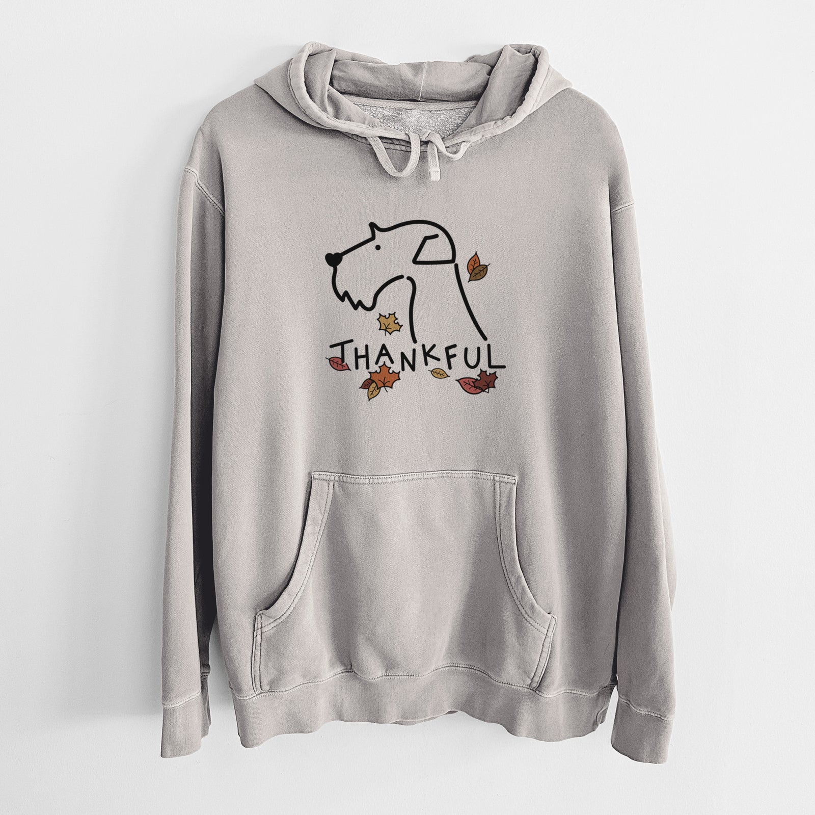 Minimalist line drawing of an Airedale Terrier with 'Thankful' lettering on a Cement Unisex pigment dyed hoodie