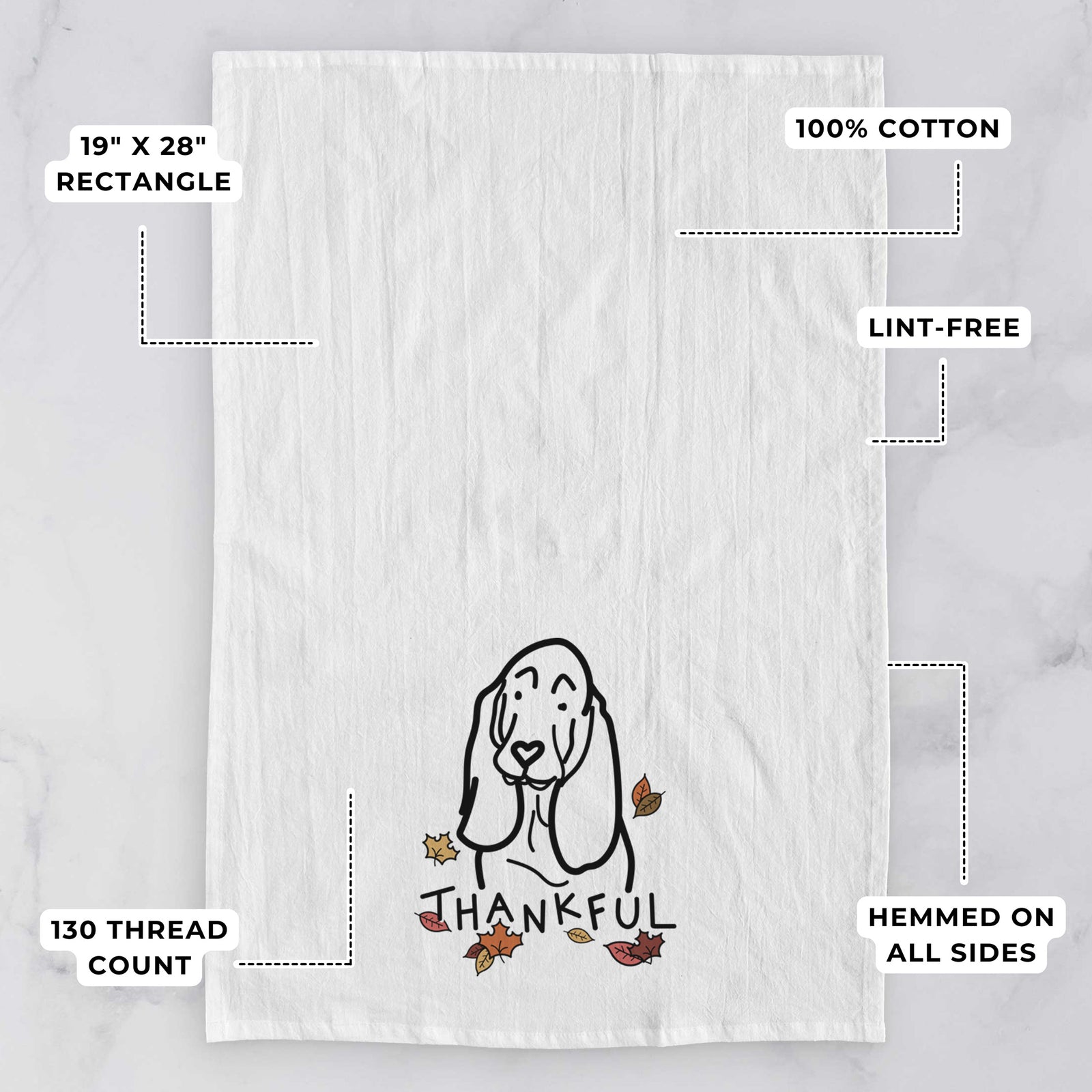 Minimalist line drawing of a Basset Hound with 'Thankful' lettering on a tea towel, with feature callouts: 19 x 28 inch rectangle, 100% cotton, lint-free, 120 thread count, hemmed on all sides