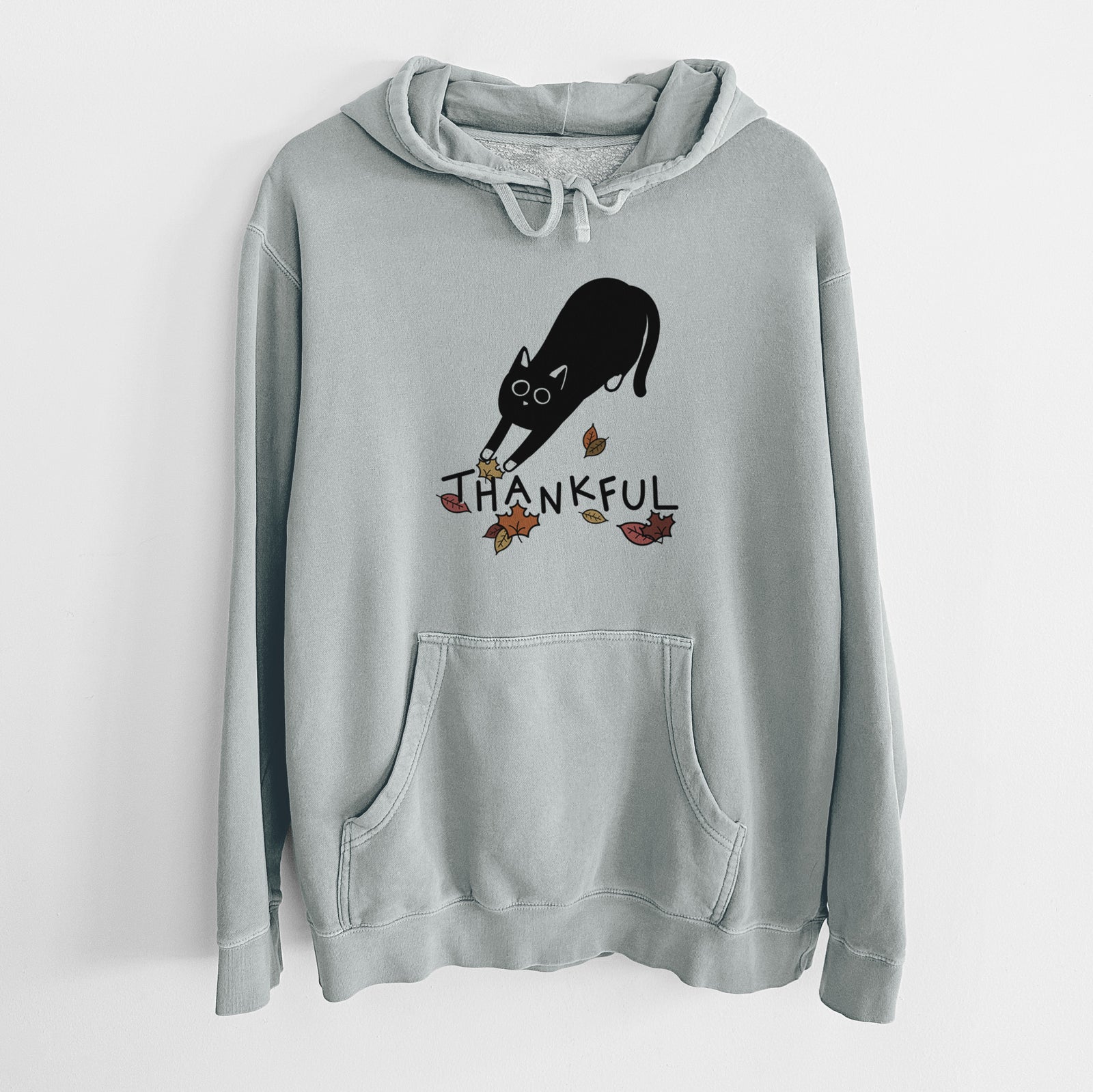 Minimalist line drawing of Bug the Black Cat with 'Thankful' lettering on a Sage Unisex pigment dyed hoodie