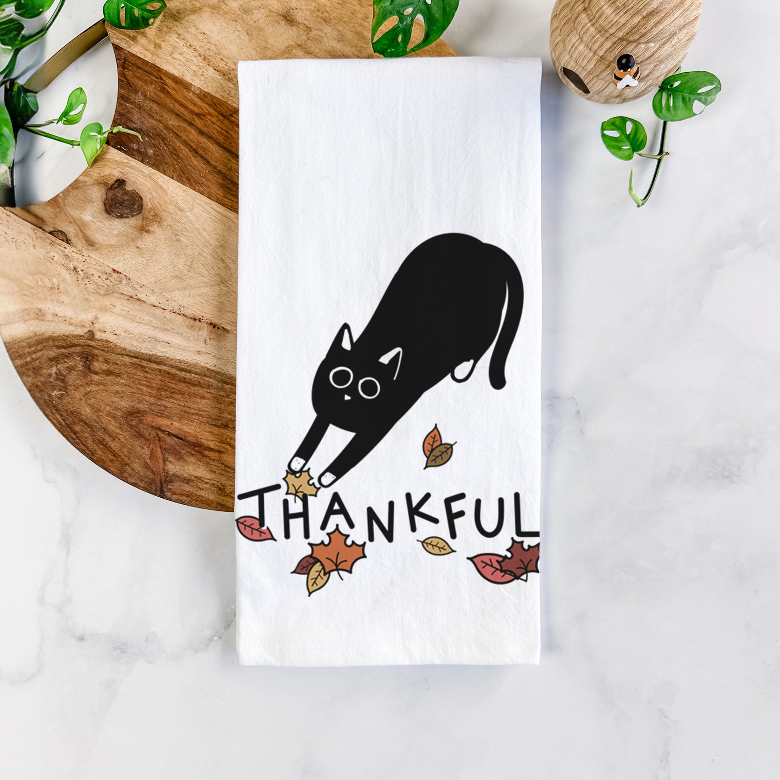 Minimalist line drawing of Bug the Black Cat with 'Thankful' lettering on a tea towel