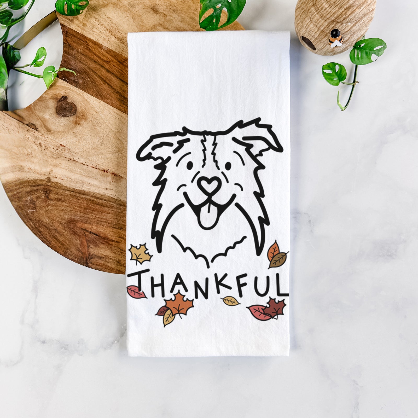 Minimalist line drawing of Cricket the Border Collie with 'Thankful' lettering on a tea towel