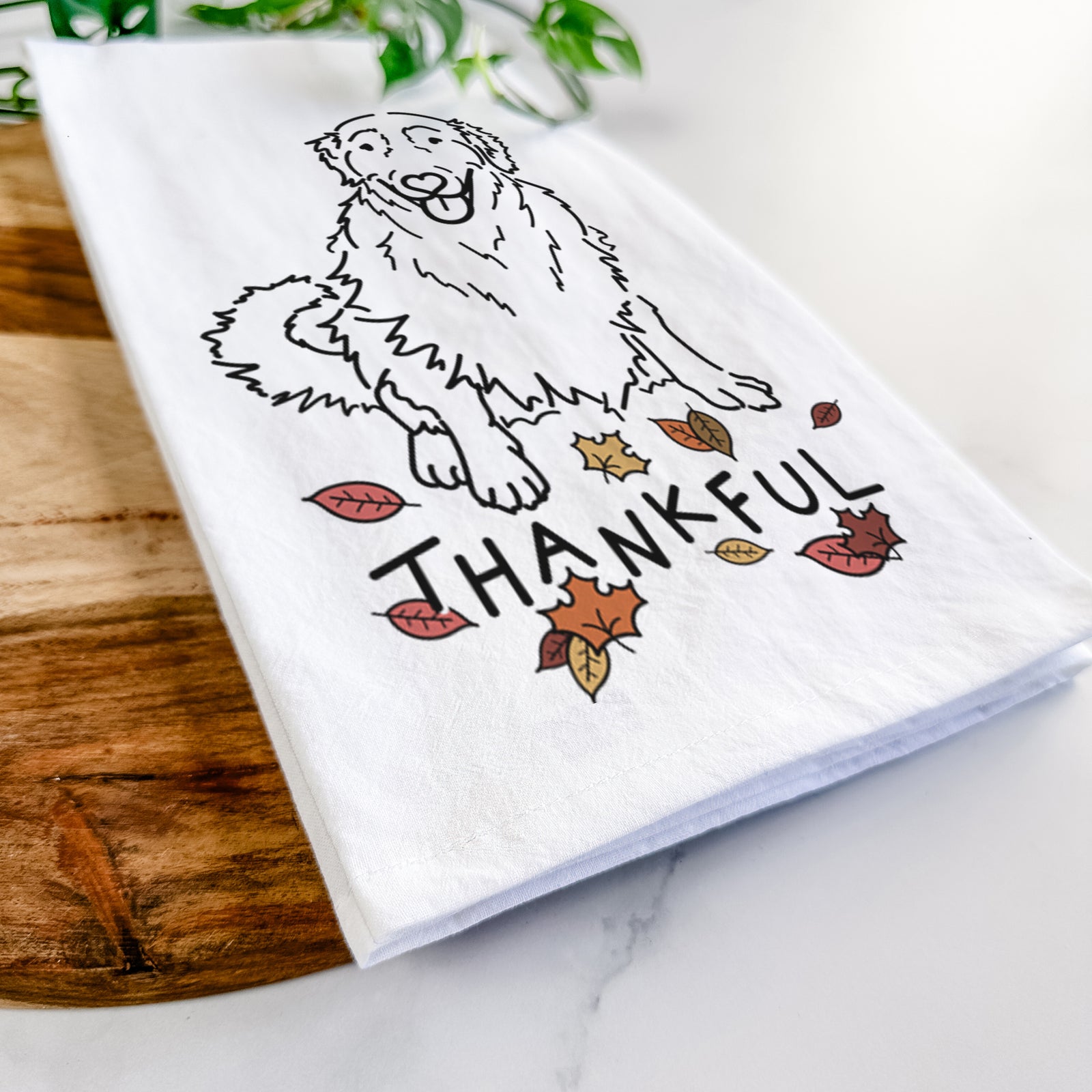 Minimalist line drawing of Daisy the Golden Retriever with 'Thankful' lettering on a tea towel
