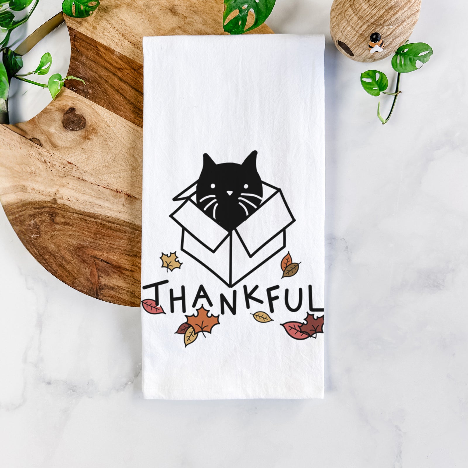 Minimalist line drawing of Doc the Black Cat in a Box with 'Thankful' lettering on a tea towel