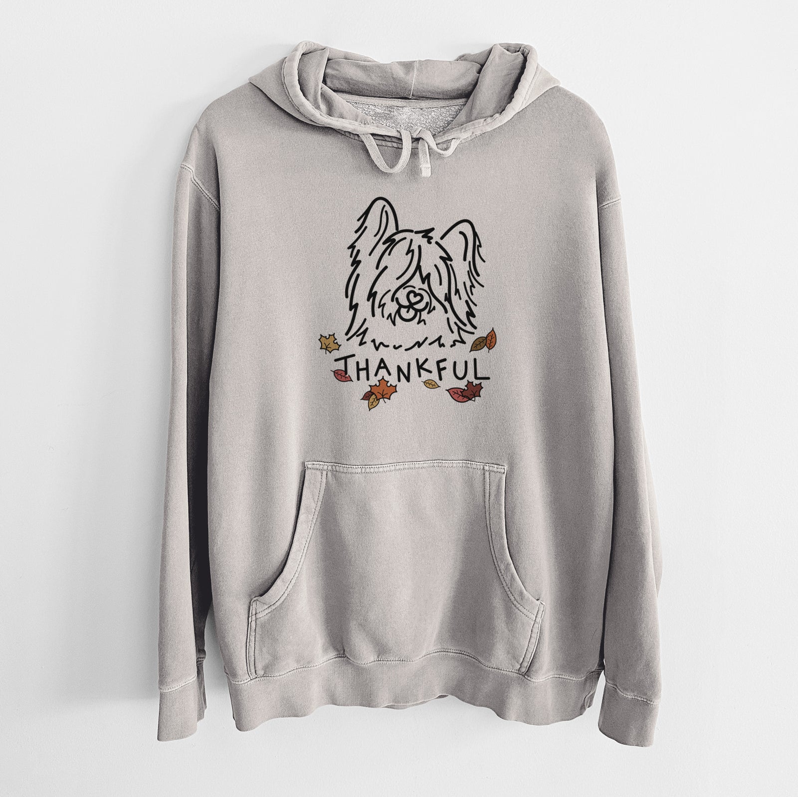 Minimalist line drawing of Dougal the Skye Terrier with 'Thankful' lettering on a Cement Unisex pigment dyed hoodie