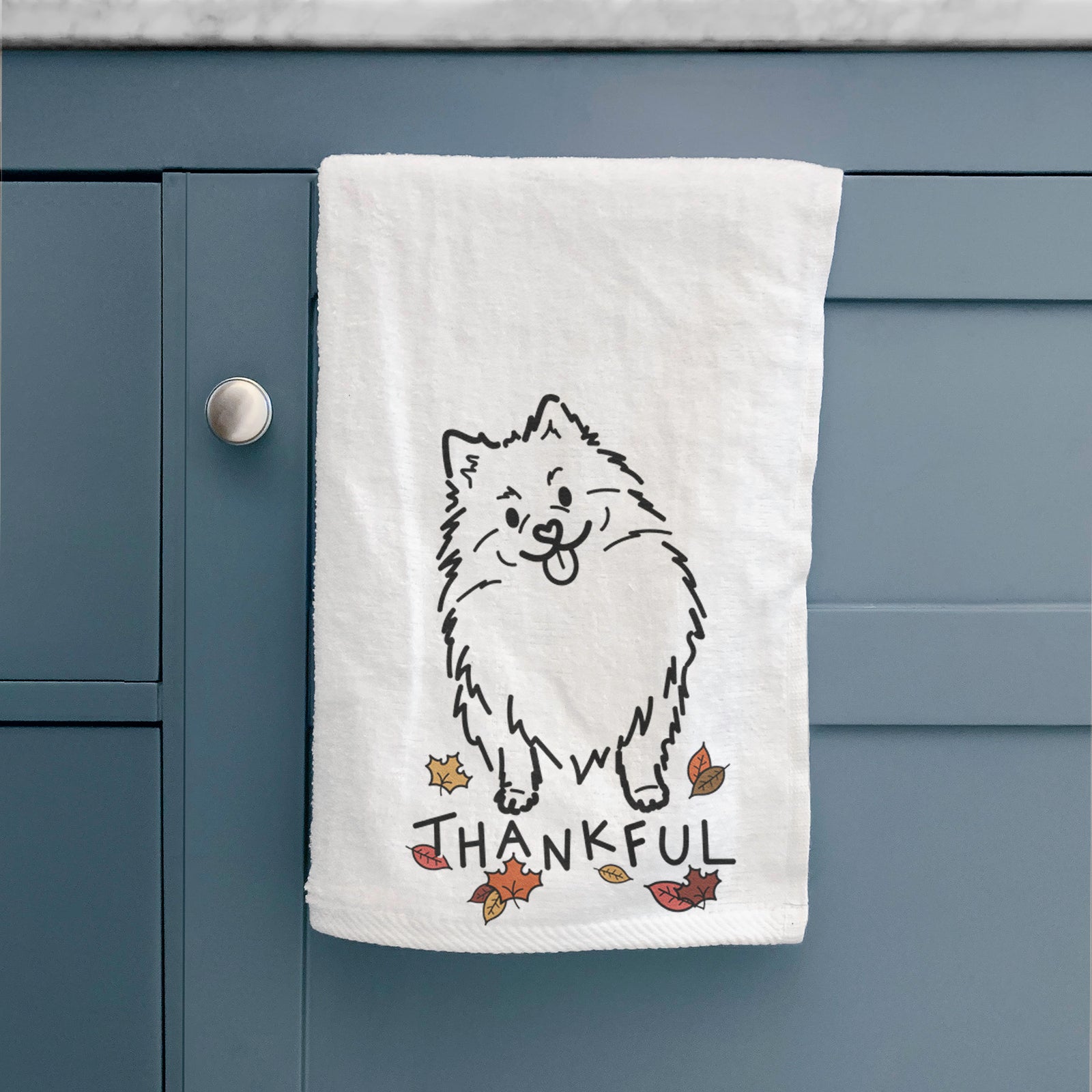 Minimalist line drawing of Fern the Pomeranian with 'Thankful' lettering on a decorative hand towel