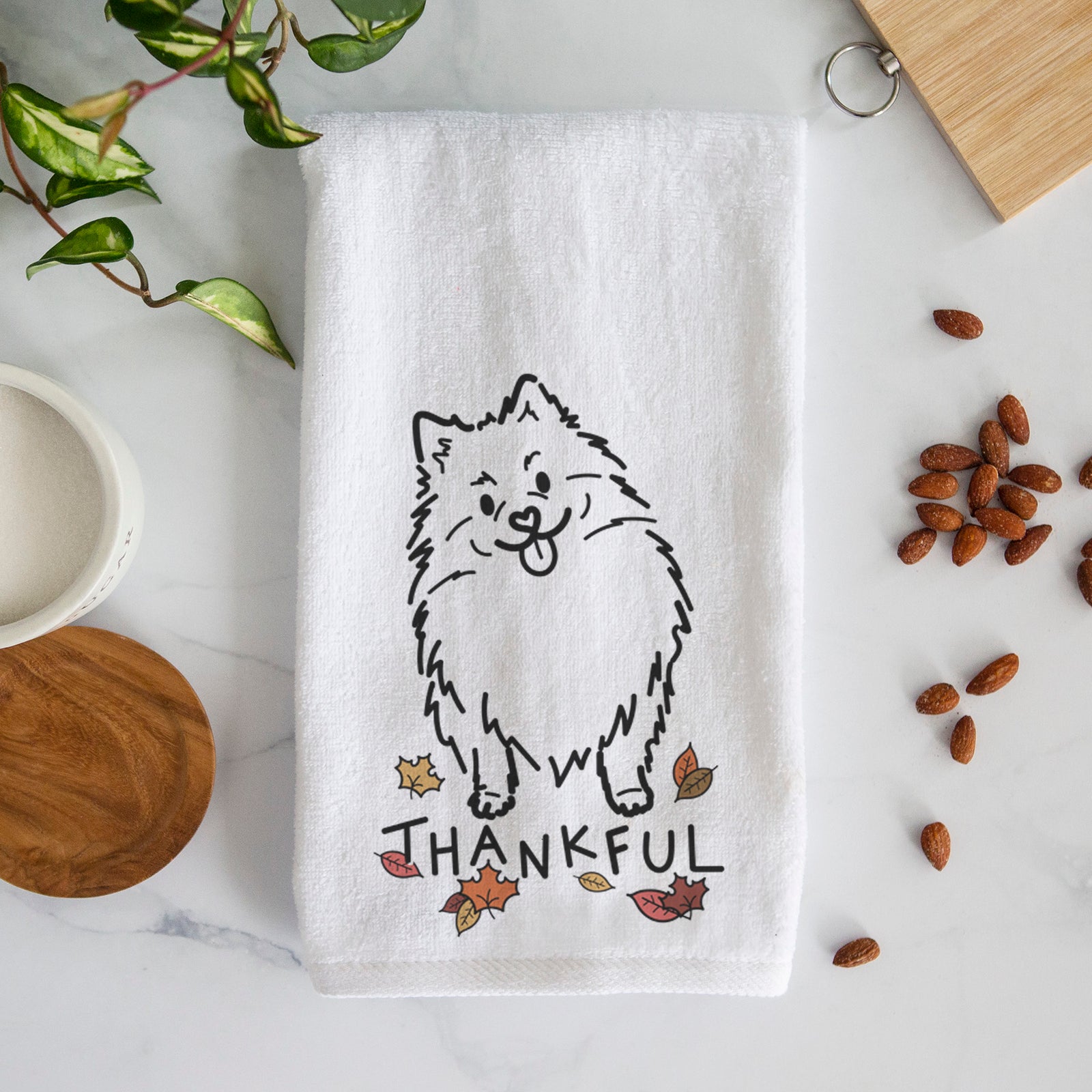 Minimalist line drawing of Fern the Pomeranian with 'Thankful' lettering on a decorative hand towel