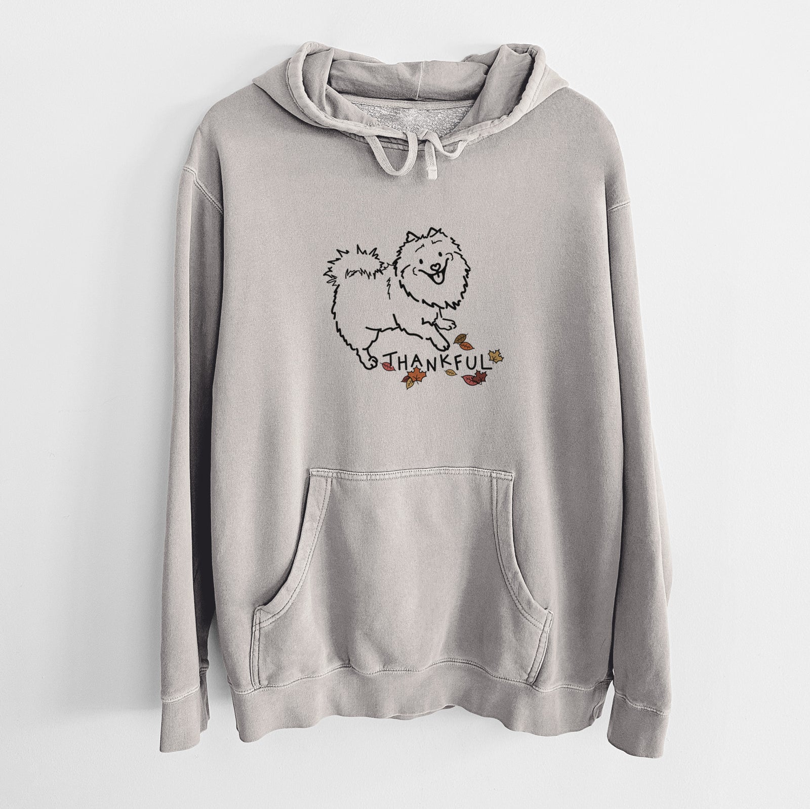 Minimalist line drawing of Goldie the Pomeranian Mix with 'Thankful' lettering on a Cement Unisex pigment dyed hoodie