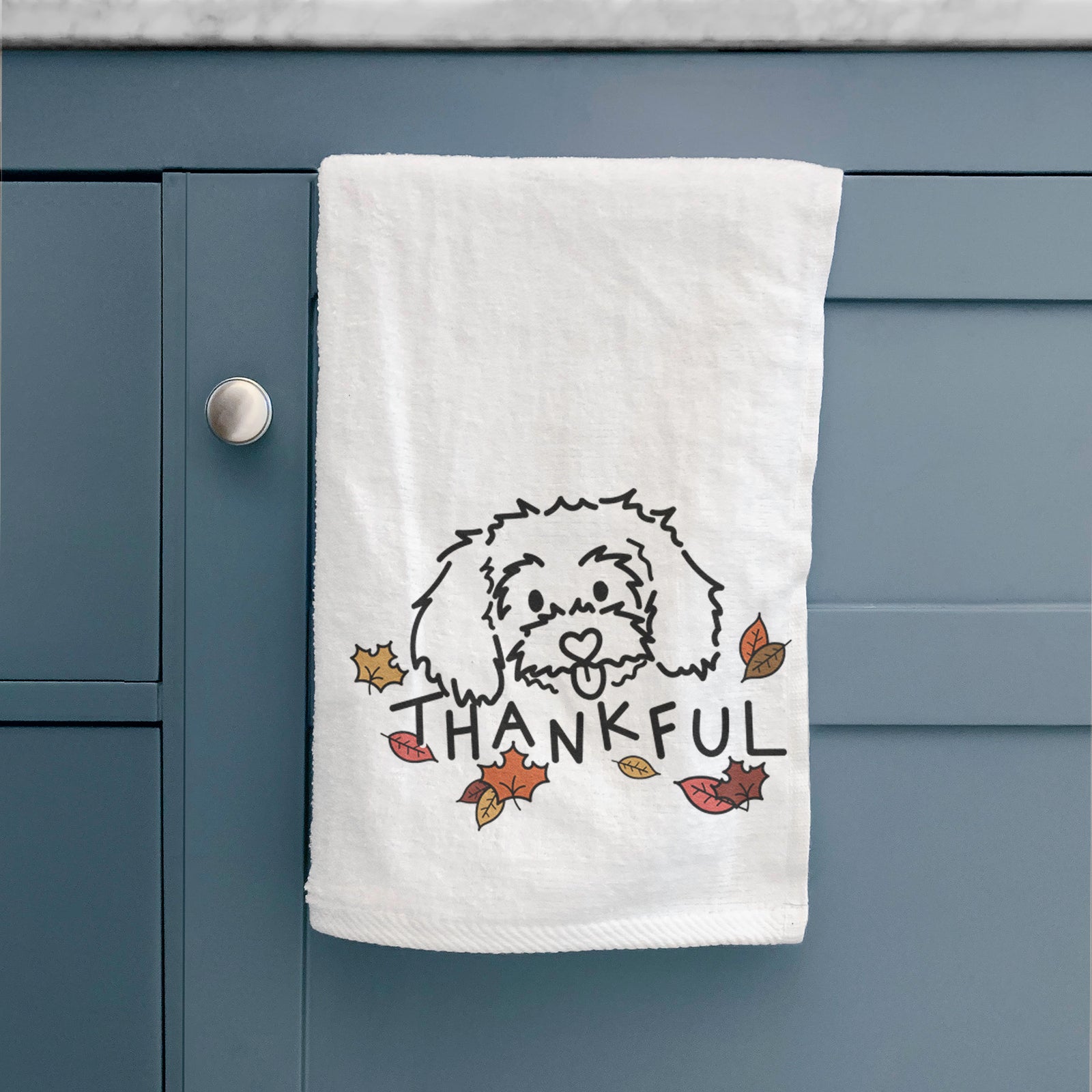 Minimalist line drawing of Holly the Maltipoo with 'Thankful' lettering on a decorative hand towel