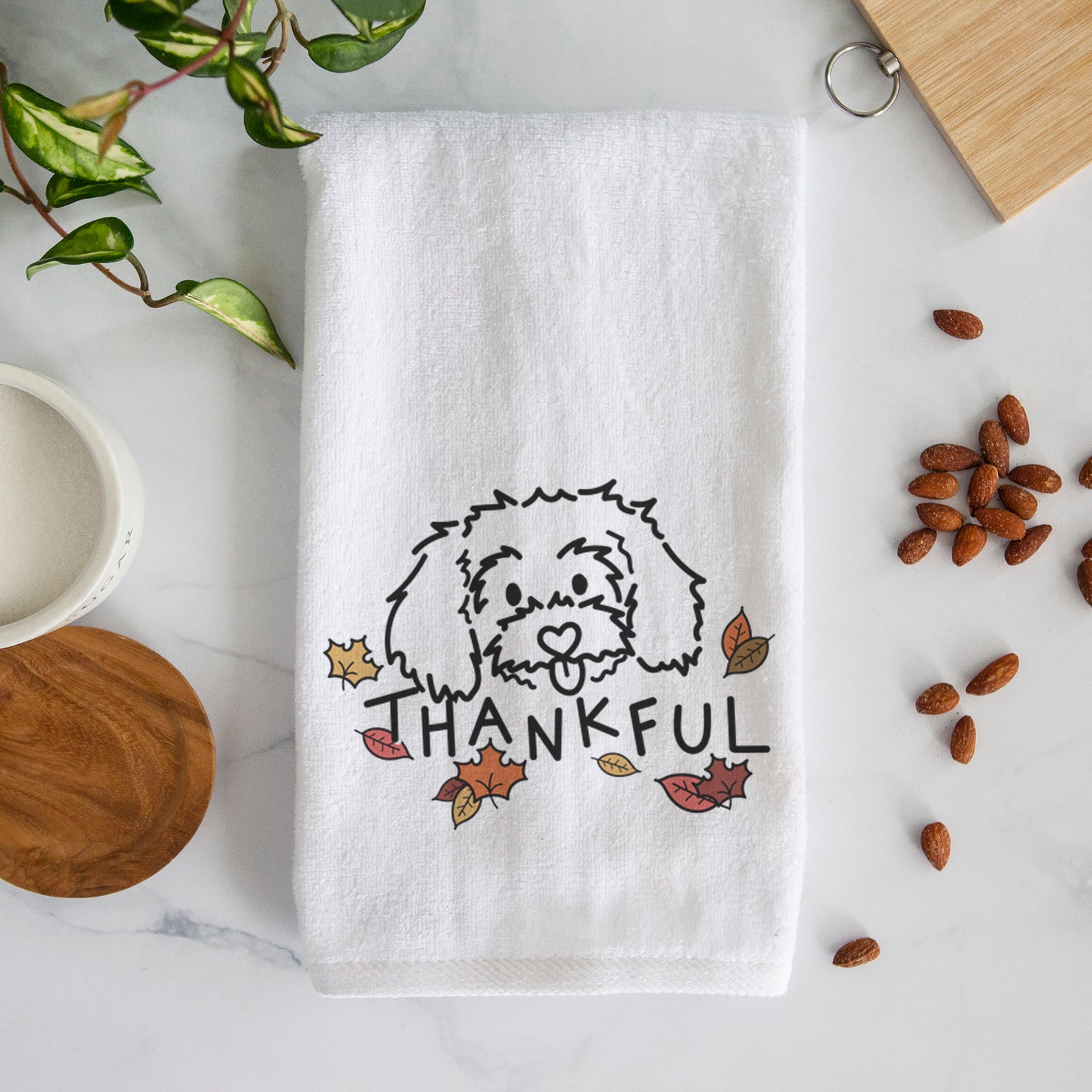 Minimalist line drawing of Holly the Maltipoo with 'Thankful' lettering on a decorative hand towel