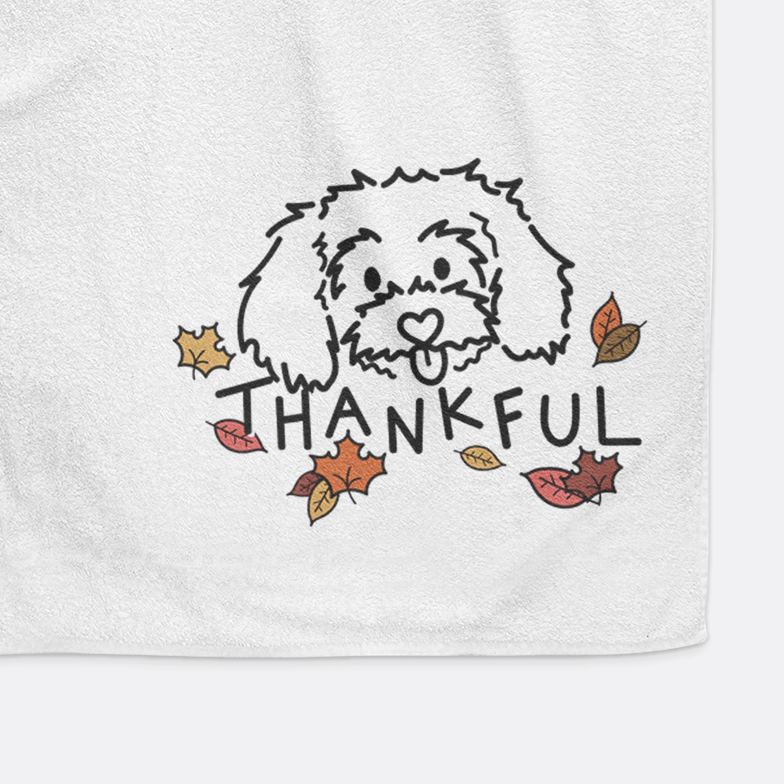 Minimalist line drawing of Holly the Maltipoo with 'Thankful' lettering on a decorative hand towel