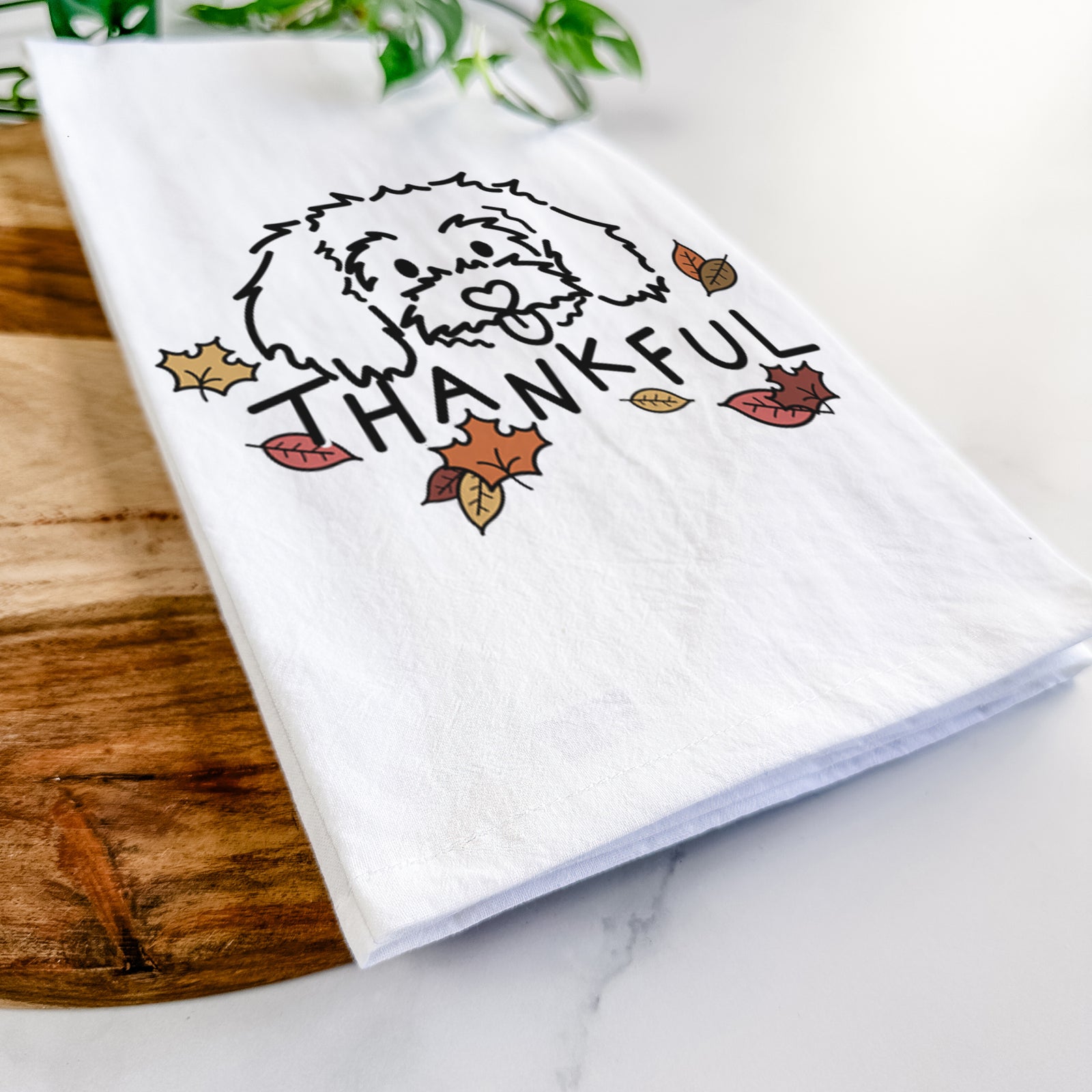 Minimalist line drawing of Holly the Maltipoo with 'Thankful' lettering on a tea towel