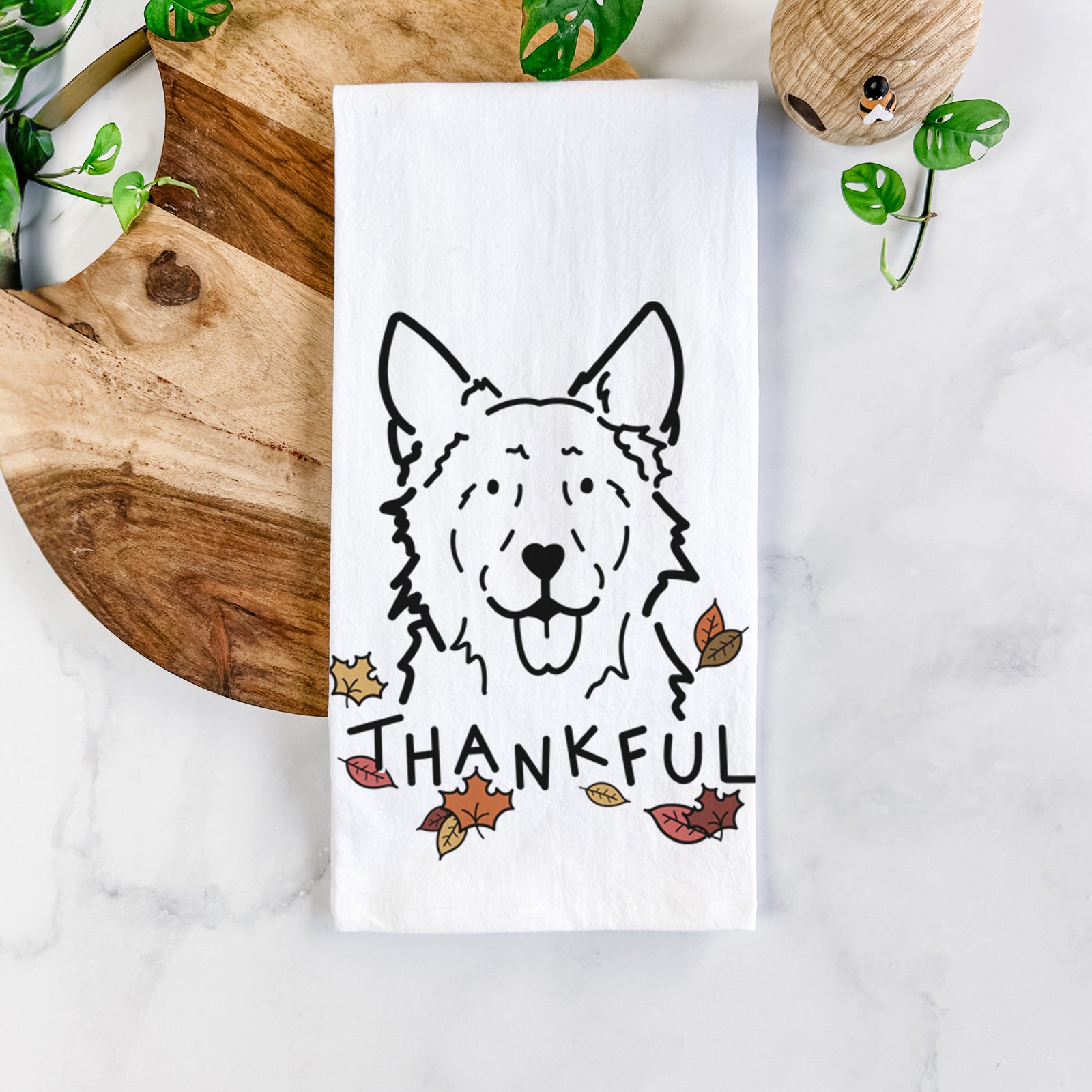 Minimalist line drawing of Jack the Mudi with 'Thankful' lettering on a tea towel