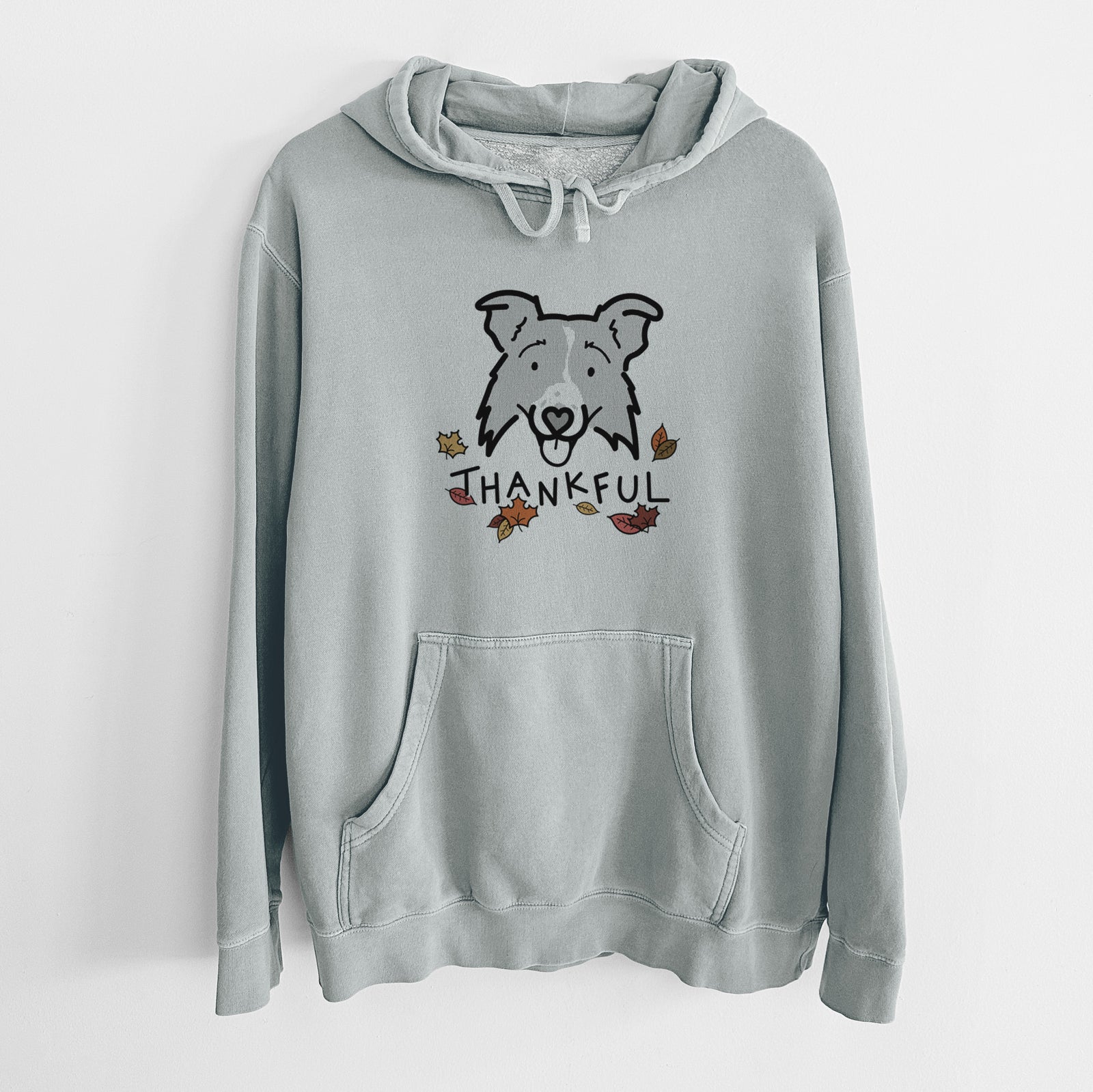 Minimalist line drawing of Jam the Border Collie 2.0 with 'Thankful' lettering on a Sage Unisex pigment dyed hoodie