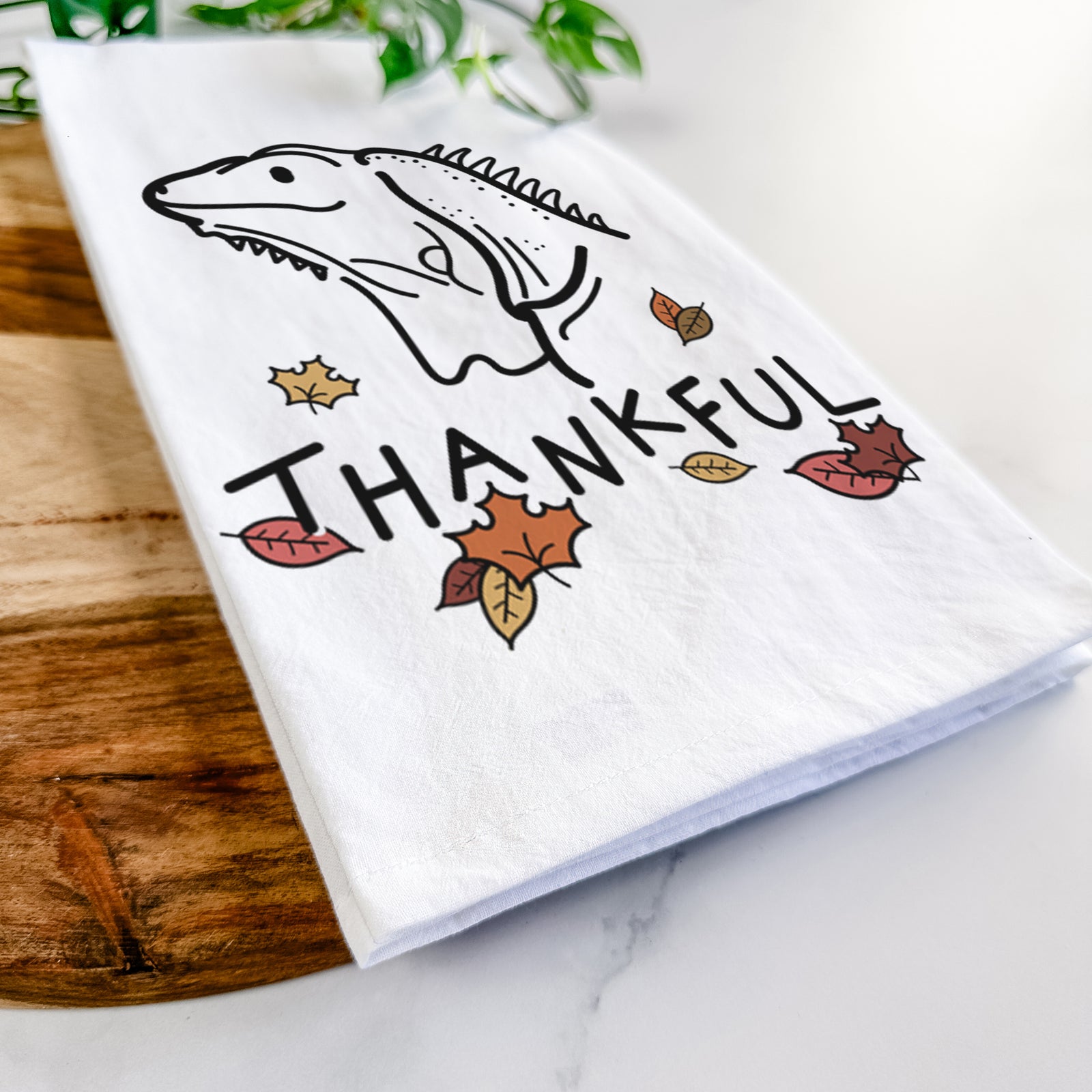 Minimalist line drawing of Louie the Iguana with 'Thankful' lettering on a tea towel