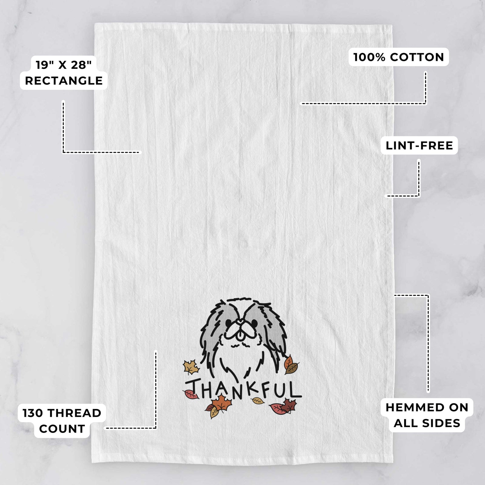 Minimalist line drawing of Macha the Japanese Chin with 'Thankful' lettering on a tea towel, with feature callouts: 19 x 28 inch rectangle, 100% cotton, lint-free, 120 thread count, hemmed on all sides
