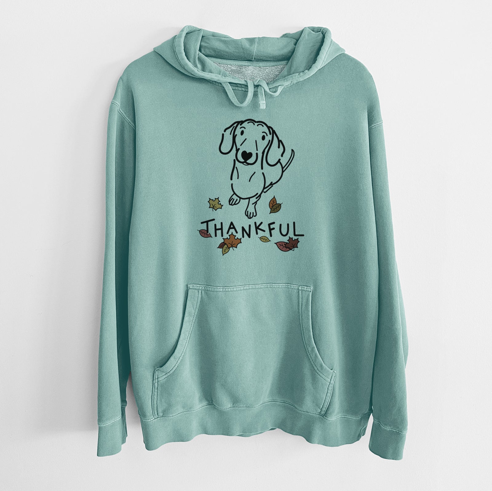 Minimalist line drawing of Moxie the Dachshund with 'Thankful' lettering on a Mint Unisex pigment dyed hoodie