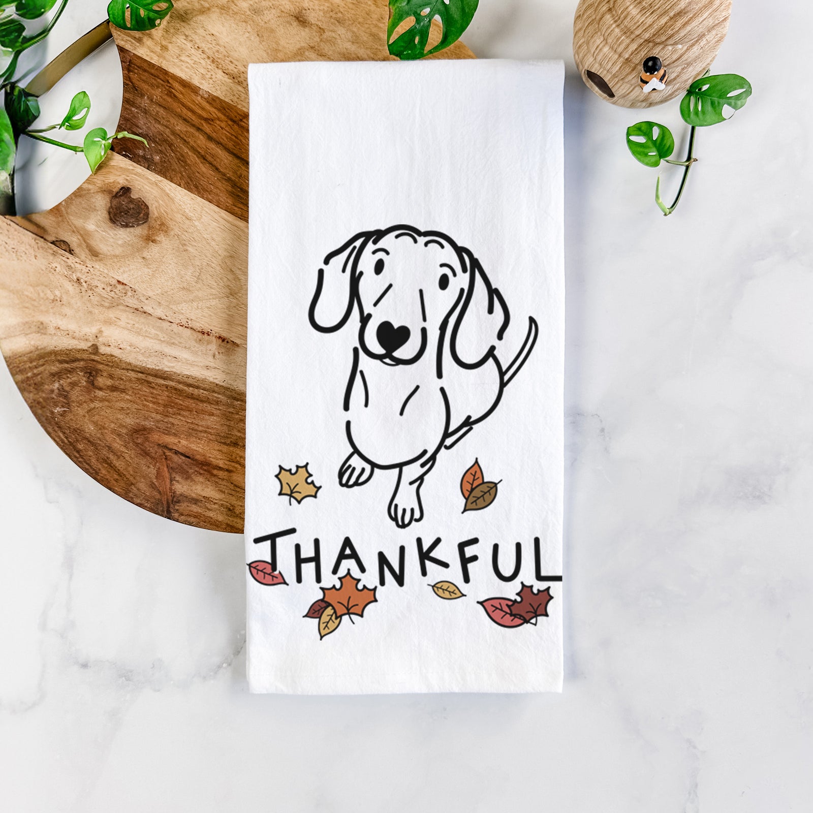 Minimalist line drawing of Moxie the Dachshund with 'Thankful' lettering on a tea towel