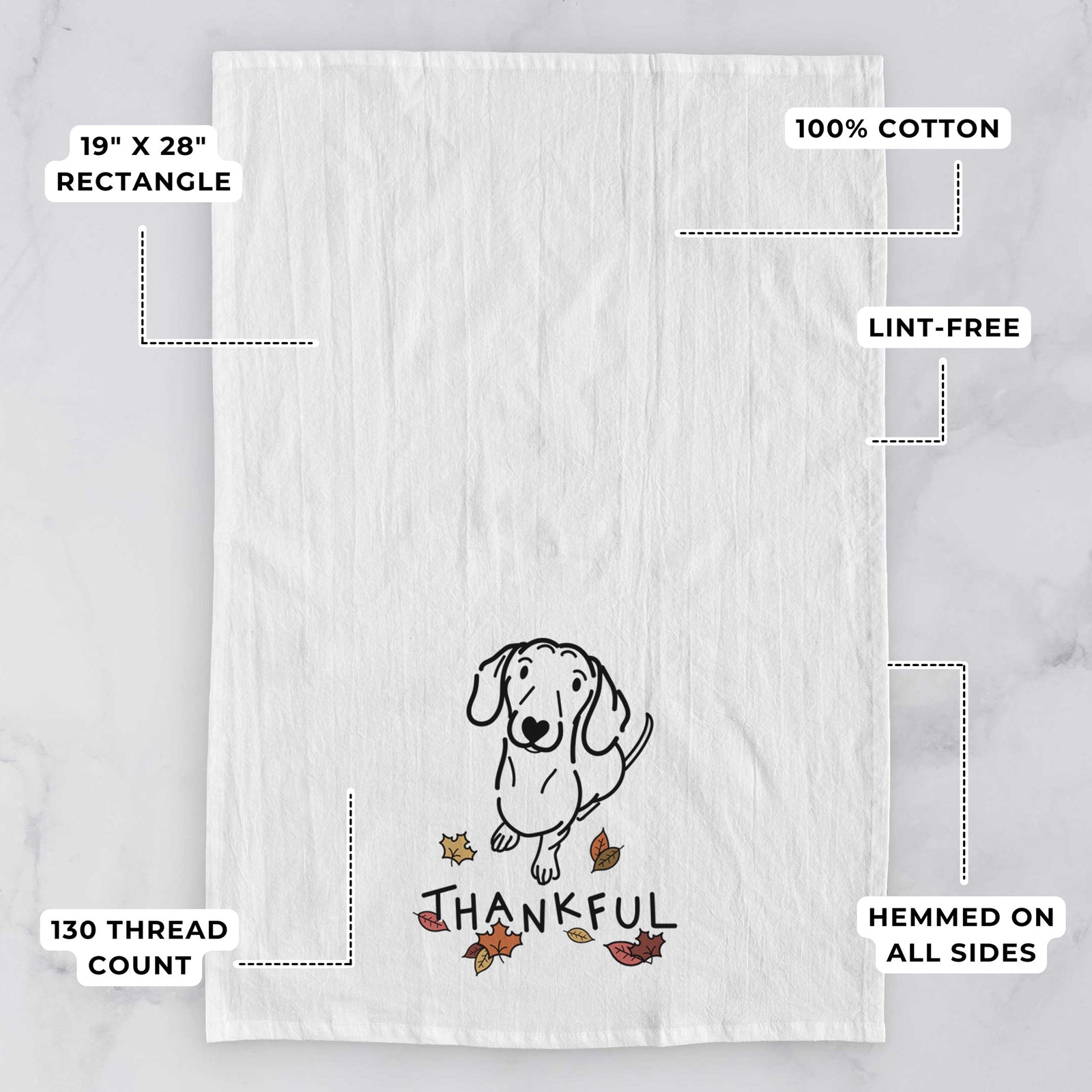 Minimalist line drawing of Moxie the Dachshund with 'Thankful' lettering on a tea towel, with feature callouts: 19 x 28 inch rectangle, 100% cotton, lint-free, 120 thread count, hemmed on all sides