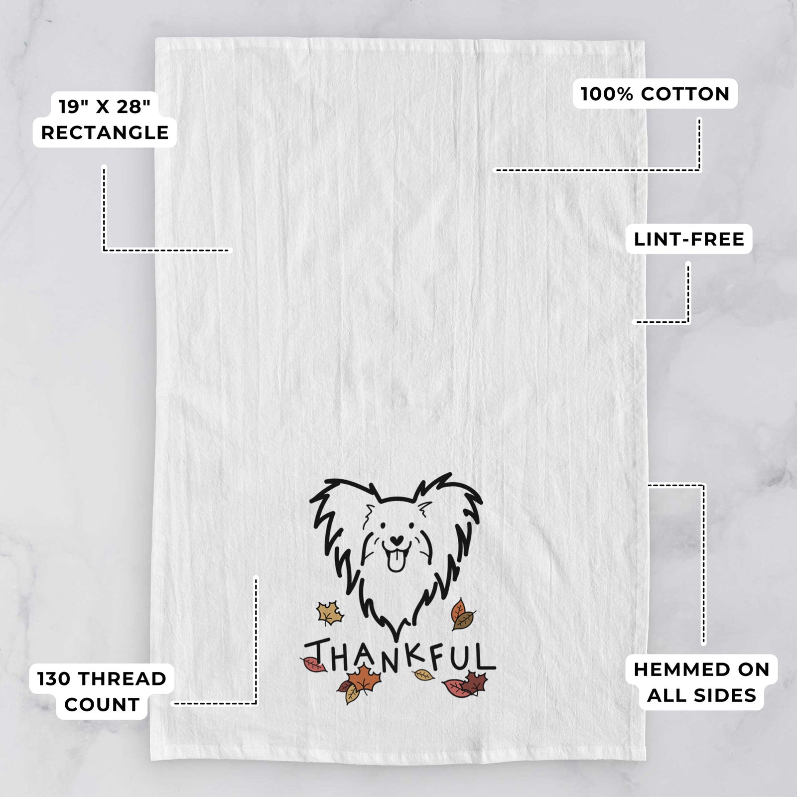 Minimalist line drawing of a Papillon with 'Thankful' lettering on a tea towel, with feature callouts: 19 x 28 inch rectangle, 100% cotton, lint-free, 120 thread count, hemmed on all sides