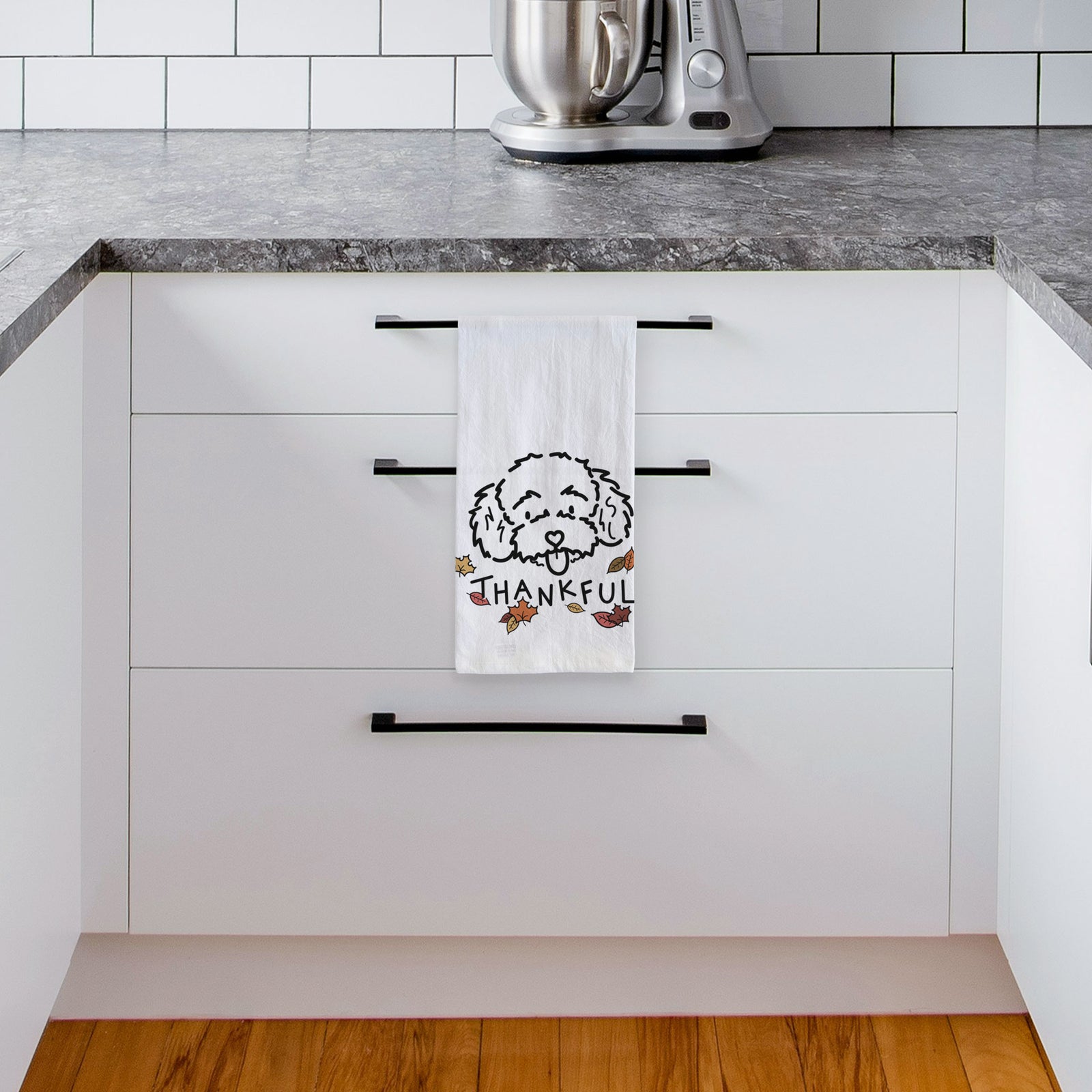 Minimalist line drawing of Ricci the Toy Poodle with 'Thankful' lettering on a tea towel, hanging on an oven door in a kitchen