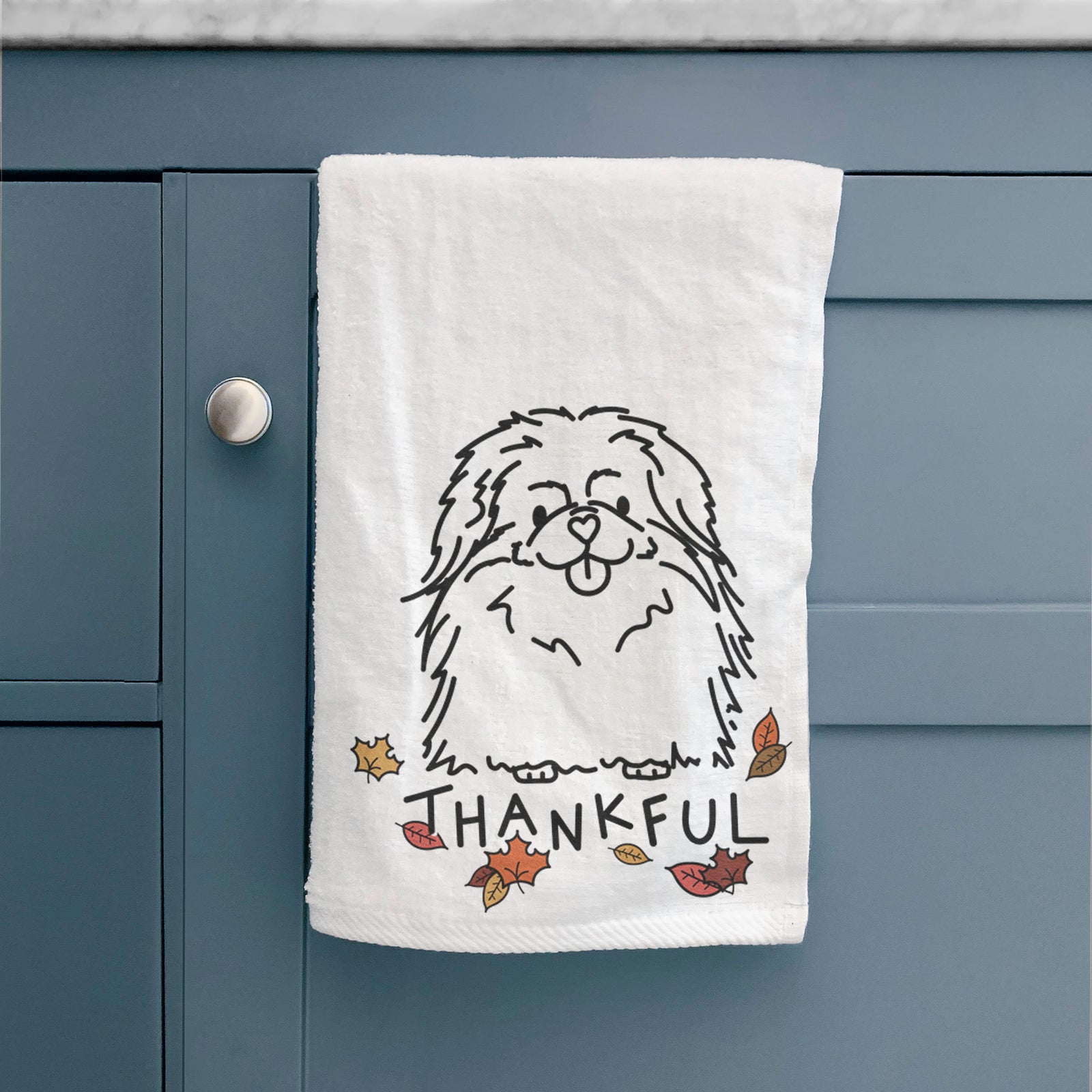 Minimalist line drawing of Viv the Pekingese with 'Thankful' lettering on a decorative hand towel