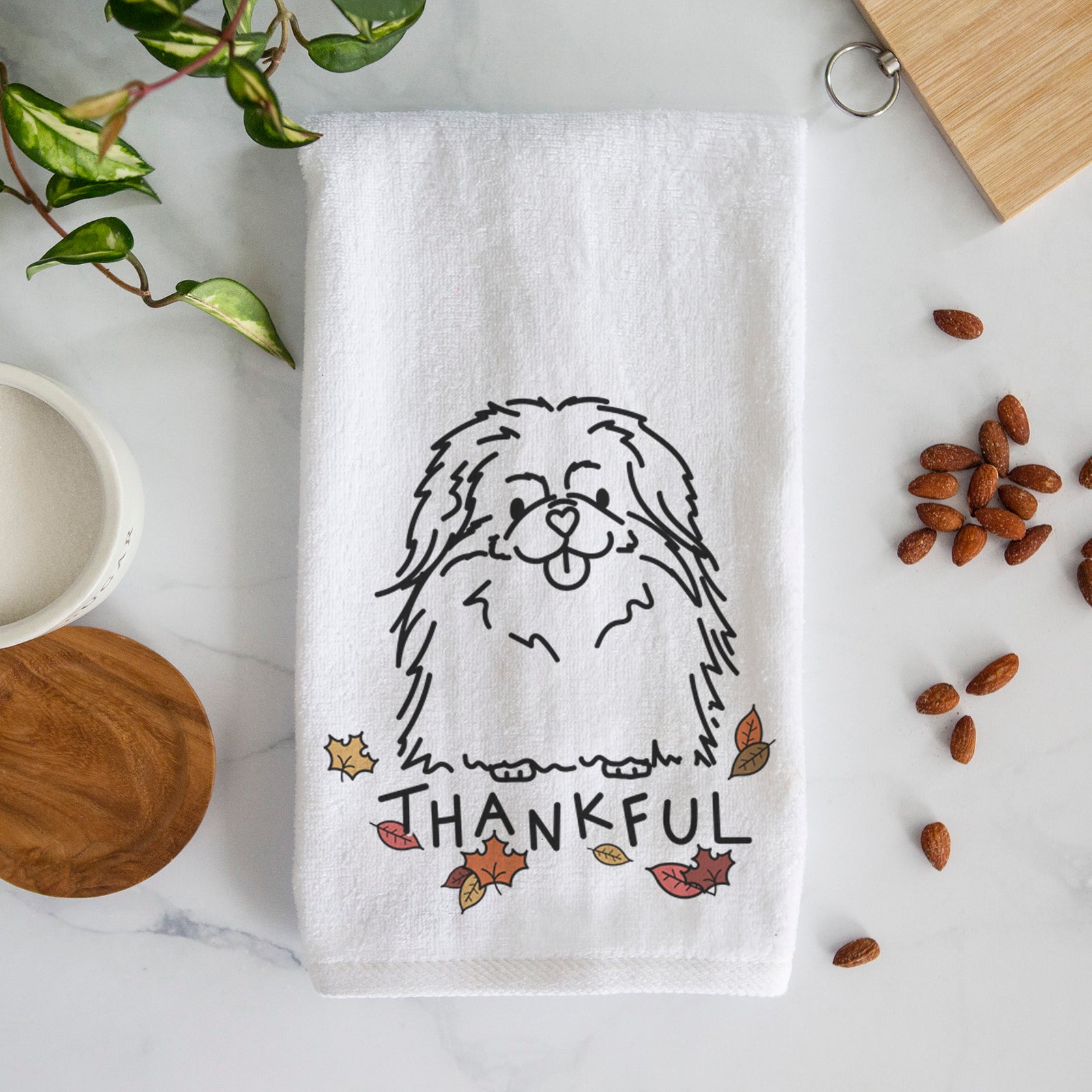 Minimalist line drawing of Viv the Pekingese with 'Thankful' lettering on a decorative hand towel