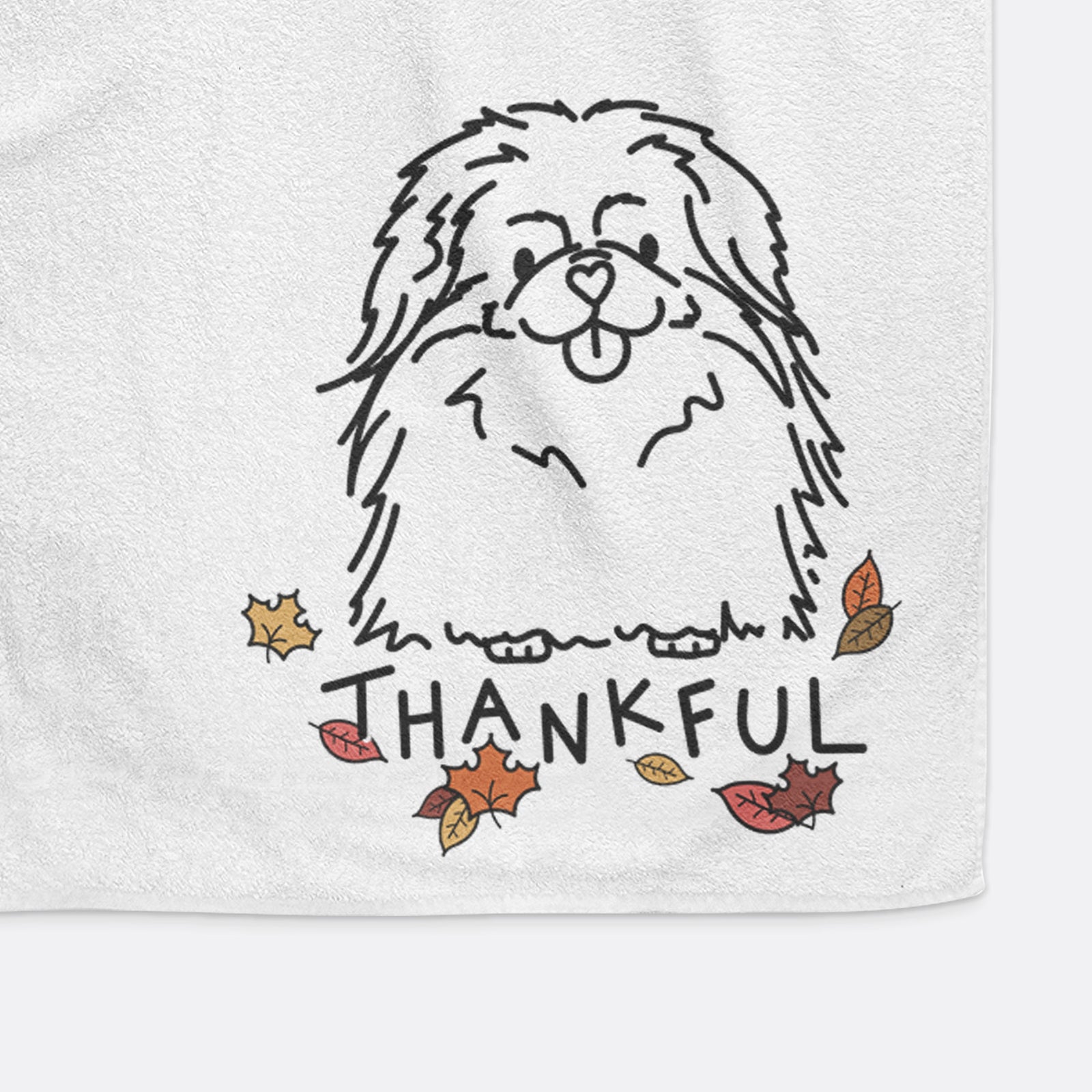 Minimalist line drawing of Viv the Pekingese with 'Thankful' lettering on a decorative hand towel
