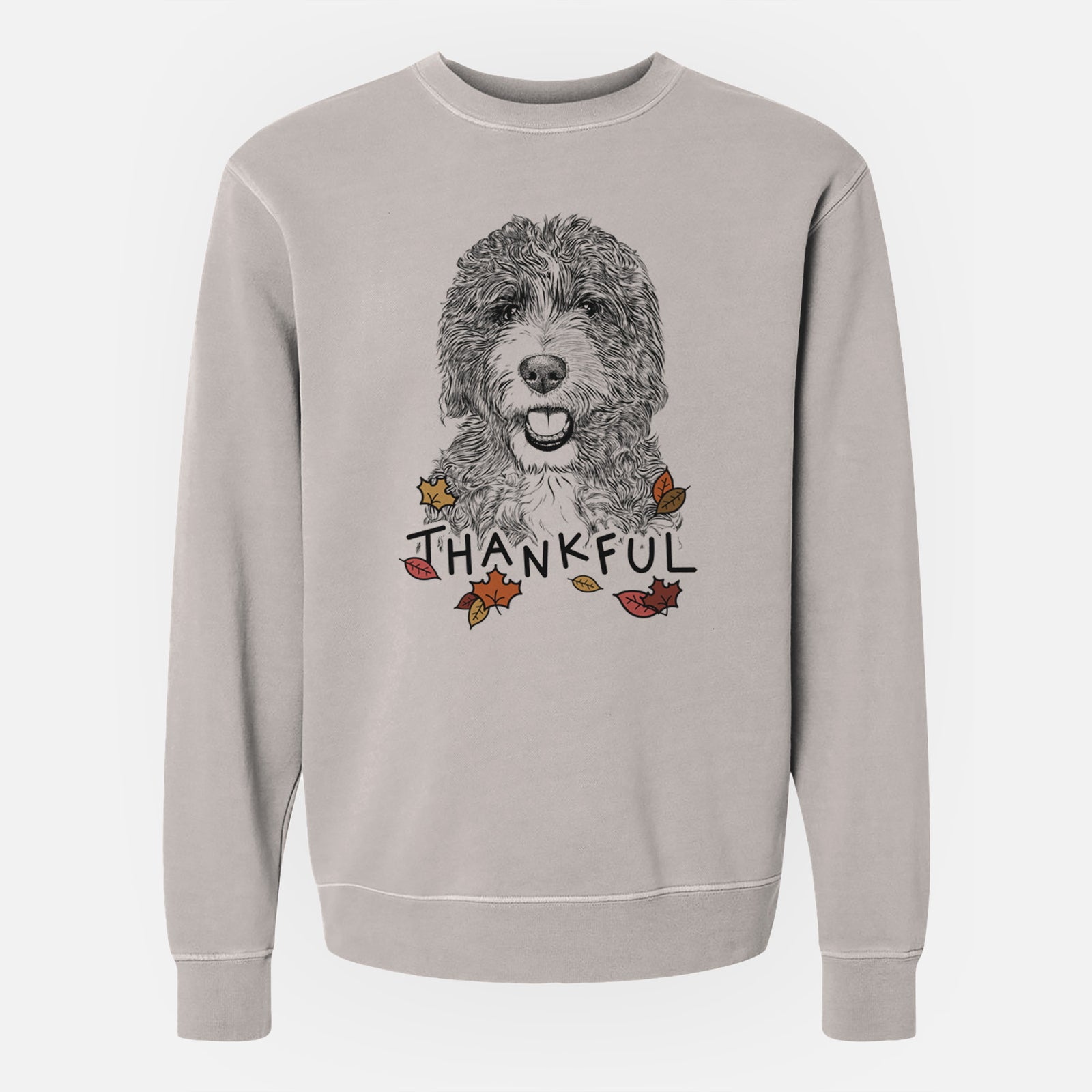 Hand-drawn sketch of Bash the Bernedoodle with 'Thankful' lettering and autumn leaves on a Cement Unisex pigment dyed crew sweatshirt