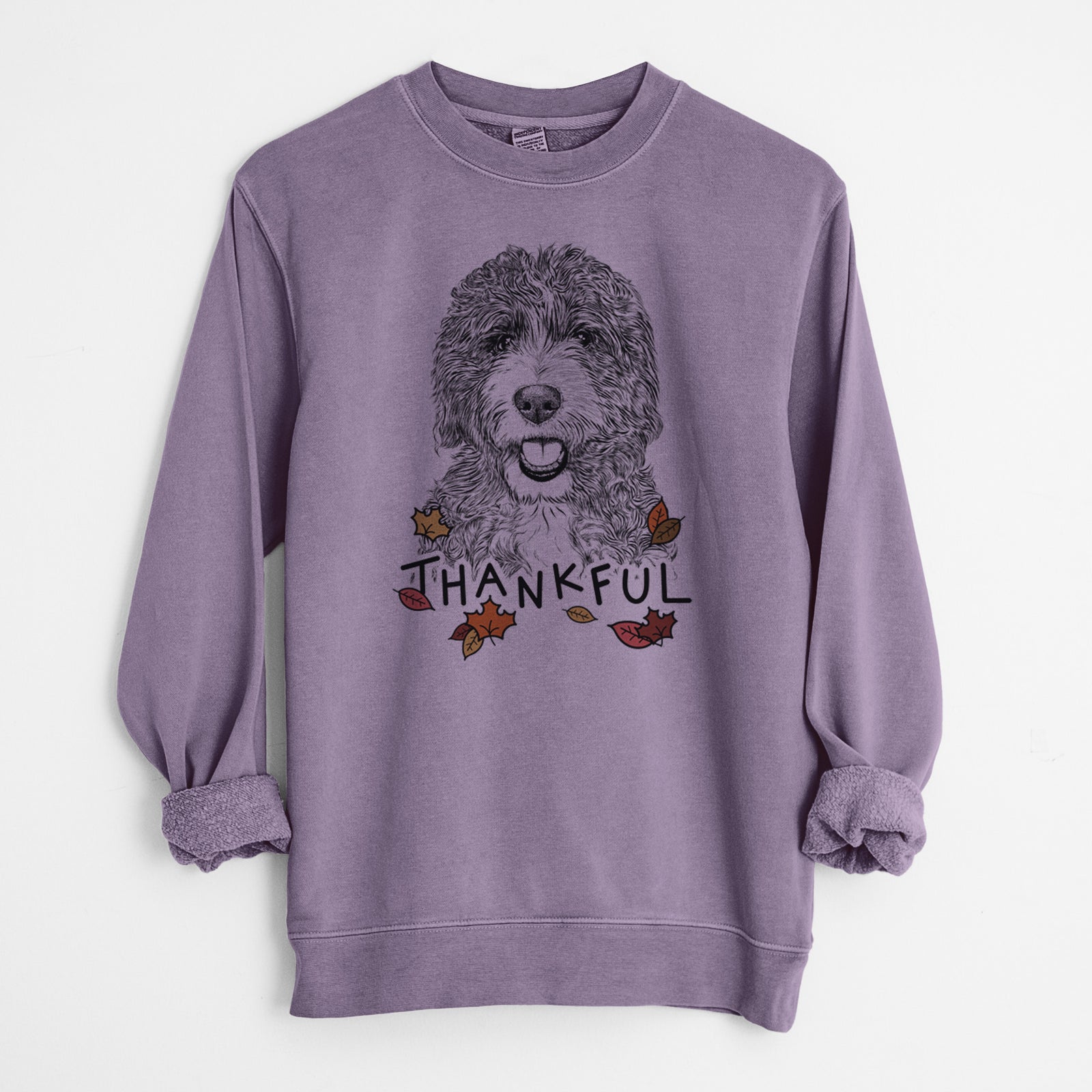 Hand-drawn sketch of Bash the Bernedoodle with 'Thankful' lettering and autumn leaves on a Plum Unisex pigment dyed crew sweatshirt