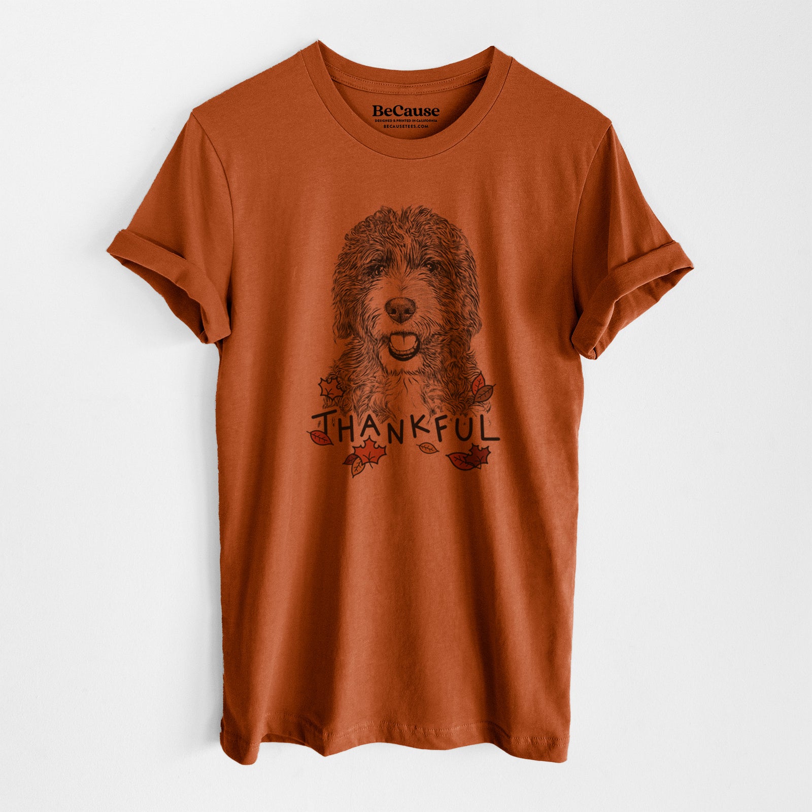 Hand-drawn sketch of Bash the Bernedoodle with 'Thankful' lettering and autumn leaves on an Autumn Unisex crewneck, worn by a model