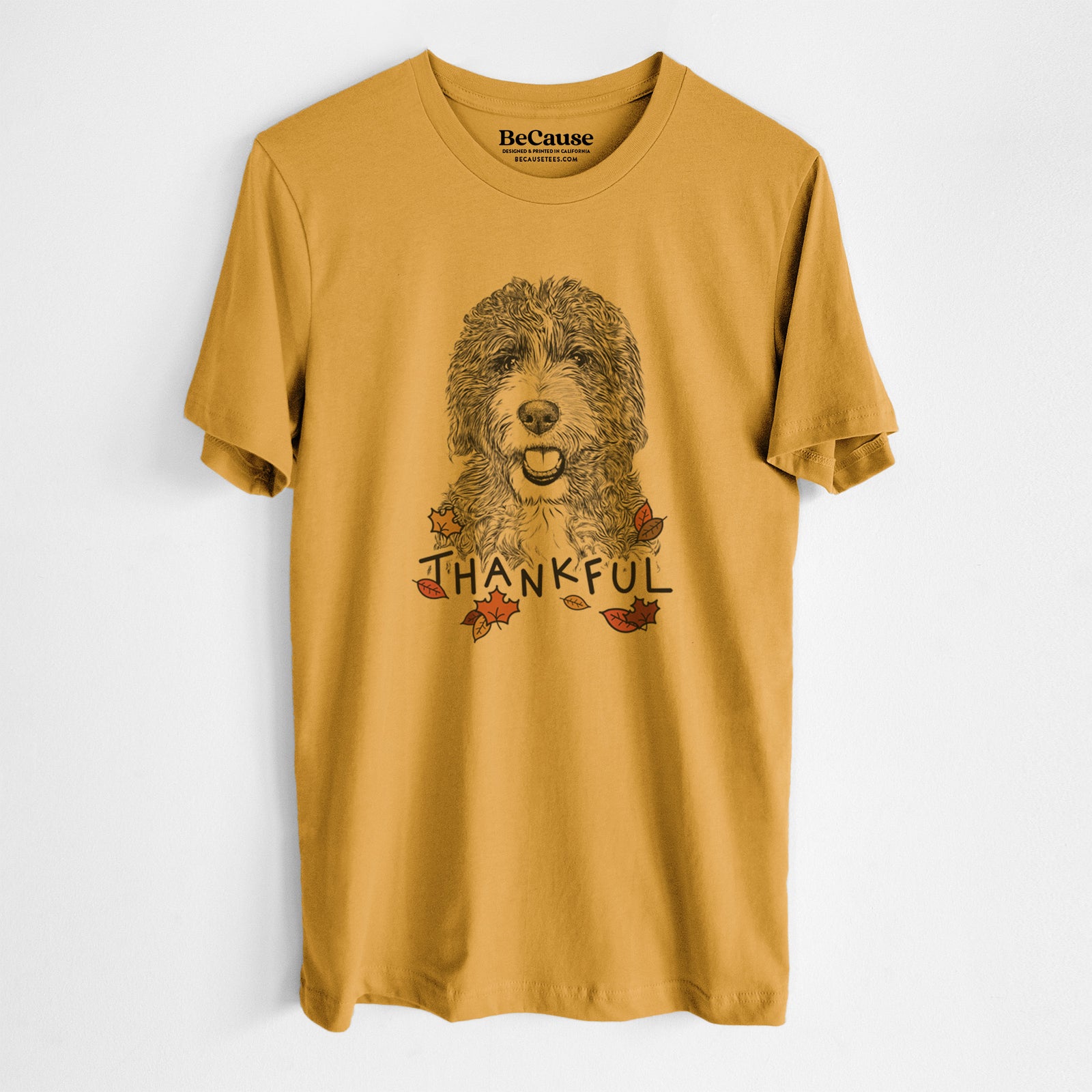 Hand-drawn sketch of Bash the Bernedoodle with 'Thankful' lettering and autumn leaves on a Mustard Unisex crewneck, worn by a man