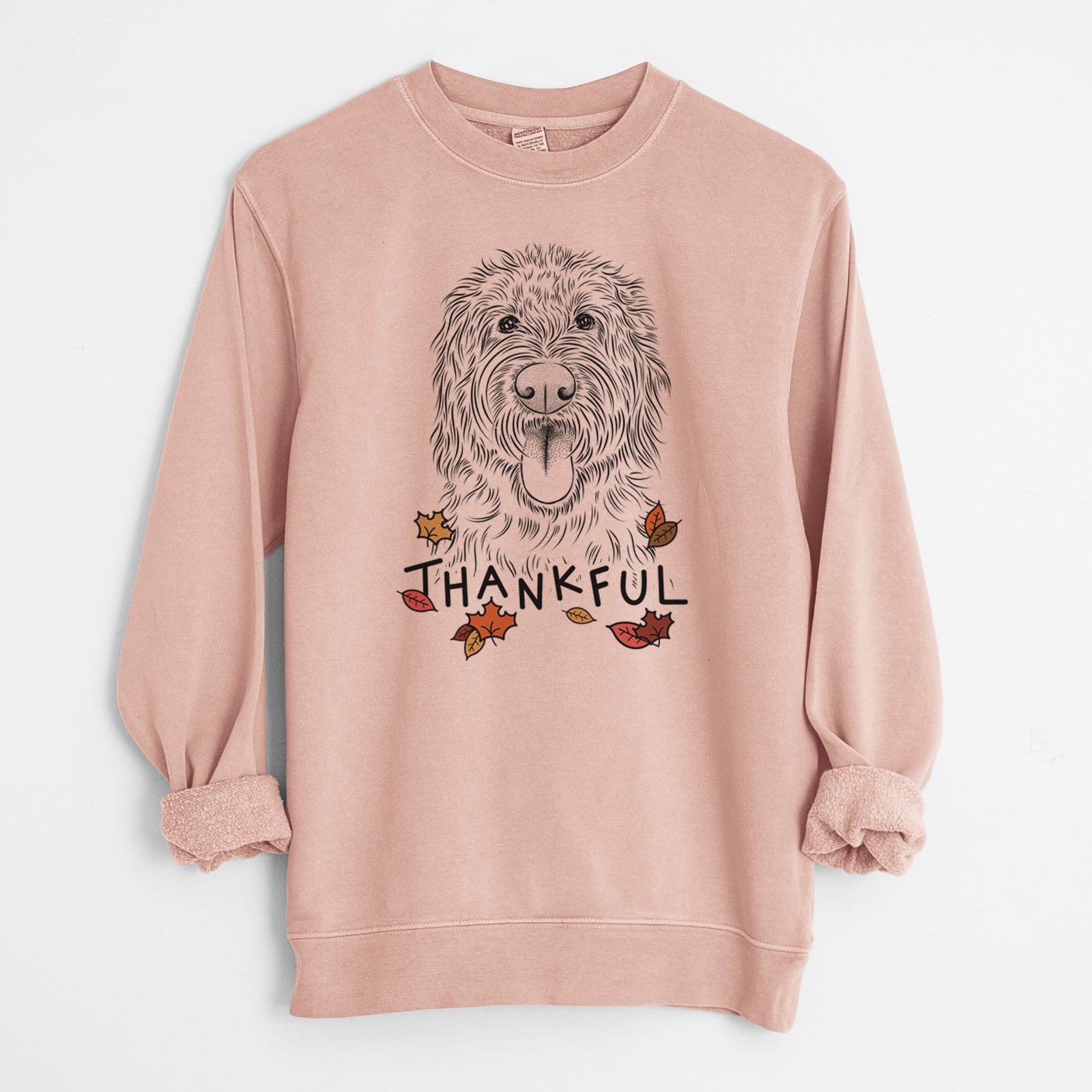 Hand-drawn sketch of Bennett the Doodle with 'Thankful' lettering and autumn leaves on a Dusty Pink Unisex pigment dyed crew sweatshirt