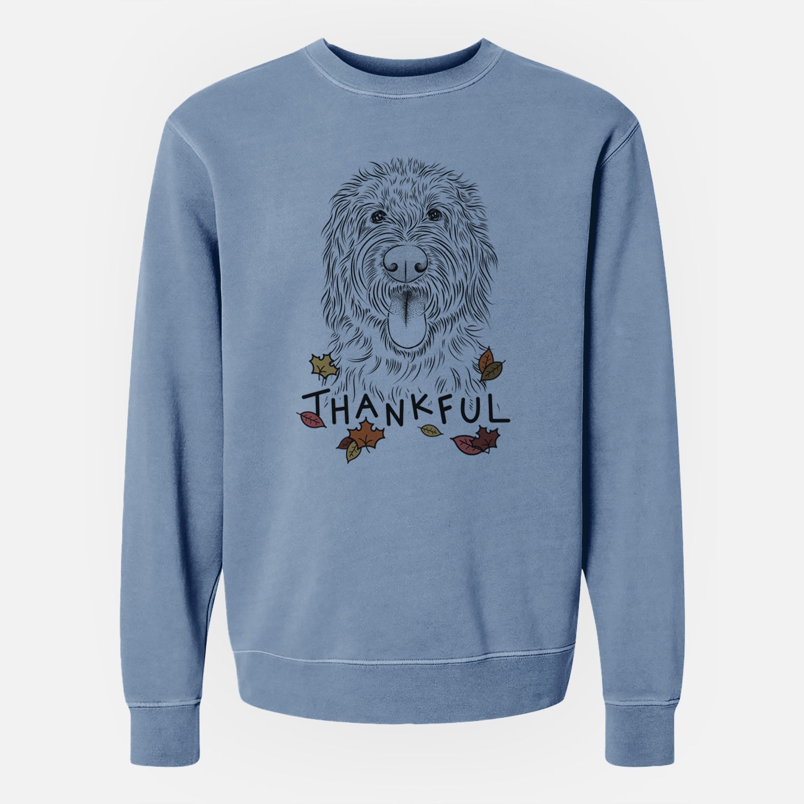 Hand-drawn sketch of Bennett the Doodle with 'Thankful' lettering and autumn leaves on a Slate Blue Unisex pigment dyed crew sweatshirt