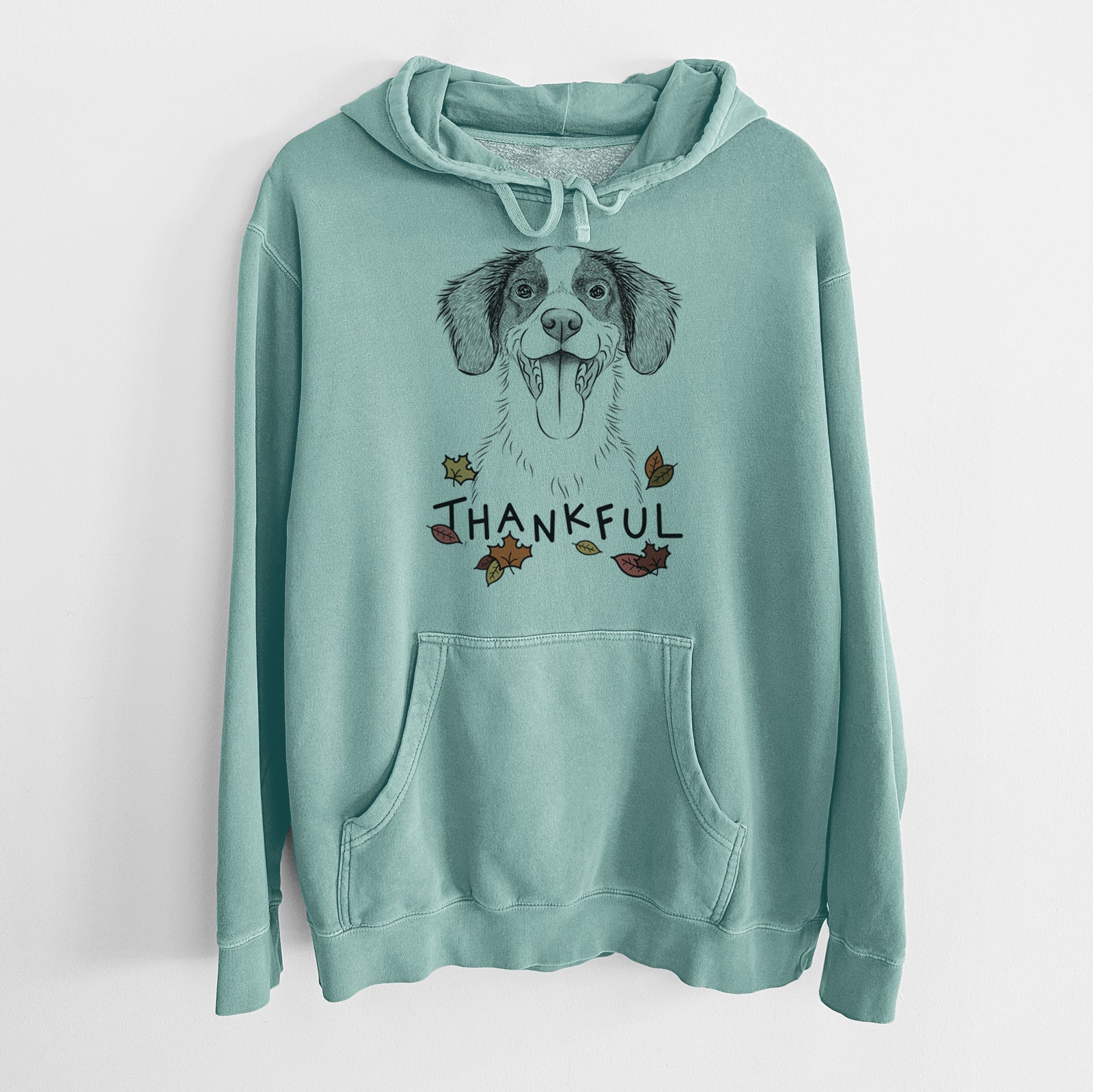 Hand-drawn sketch of Birdie the Brittany with 'Thankful' lettering and autumn leaves on a Mint Unisex pigment dyed hoodie