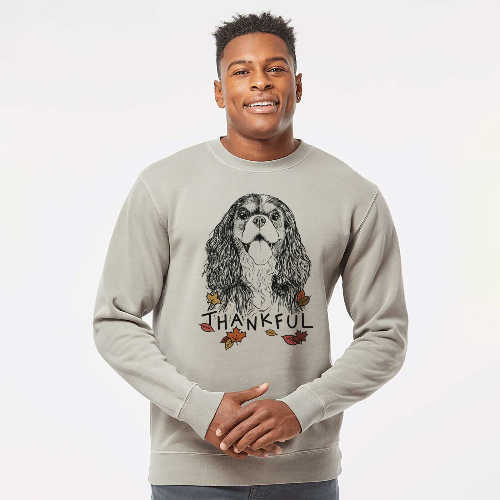 Hand-drawn sketch of Brandy the Cavalier King Charles Spaniel with 'Thankful' lettering and autumn leaves on a Cement Unisex pigment dyed crew sweatshirt