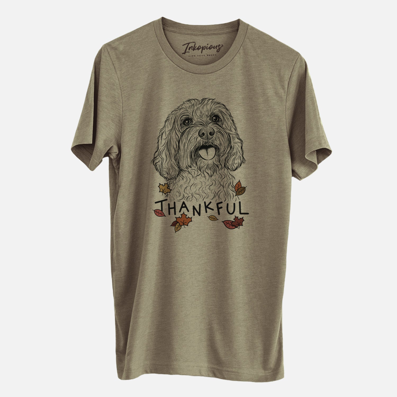 Hand-drawn sketch of Cali the Cavapoo with 'Thankful' lettering and autumn leaves on an Olive Unisex crewneck